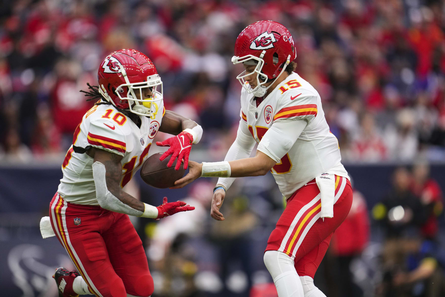 HOUSTON, TX - DECEMBER 18: Patrick Mahomes #15 of the Kansas City Chiefs hands the ball off to Isiah Pacheco #10 against the Houston Texans at NRG Stadium on December 18, 2022 in Houston, Texas. (Photo by Cooper Neill/Getty Images)