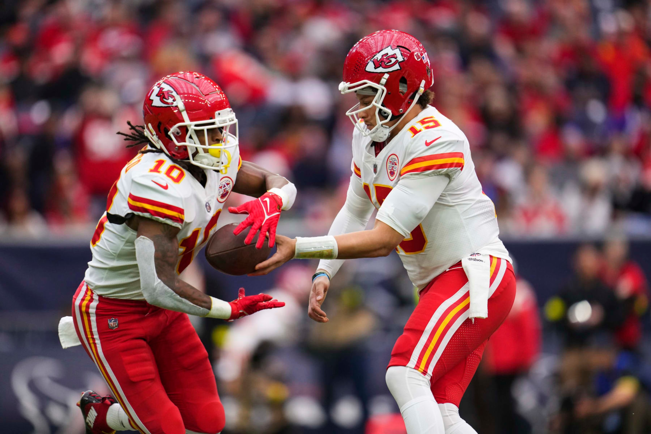 HOUSTON, TX - DECEMBER 18: Patrick Mahomes #15 of the Kansas City Chiefs hands the ball off to Isiah Pacheco #10 against the Houston Texans at NRG Stadium on December 18, 2022 in Houston, Texas. (Photo by Cooper Neill/Getty Images)