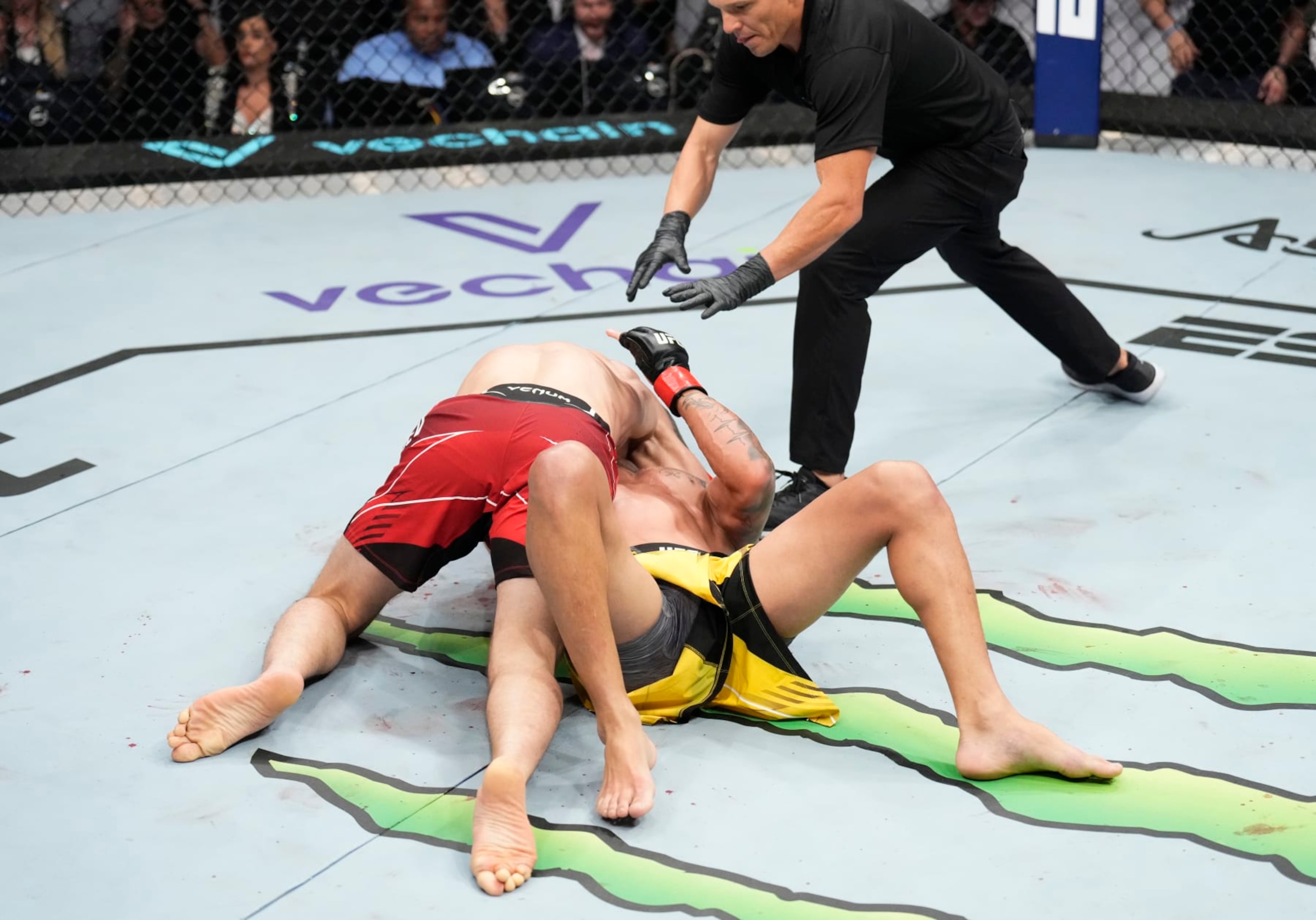 Islam Makhachev submits Charles Oliveira with an arm-triangle choke. 