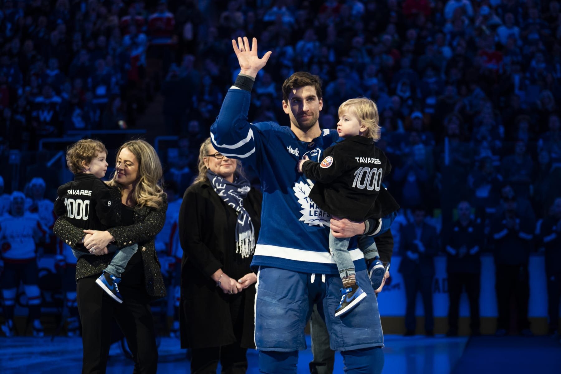 TORONTO, ON - JANUARY 29: John Tavares #91 of the Toronto Maple Leafs, joined by his family, waves to the crowd while being honoured in an on-ice ceremony ahead of his 1000th NHL game before facing the Washington Capitals at the Scotiabank Arena on January 29, 2023 in Toronto, Ontario, Canada. (Photo by Mark Blinch/NHLI via Getty Images)