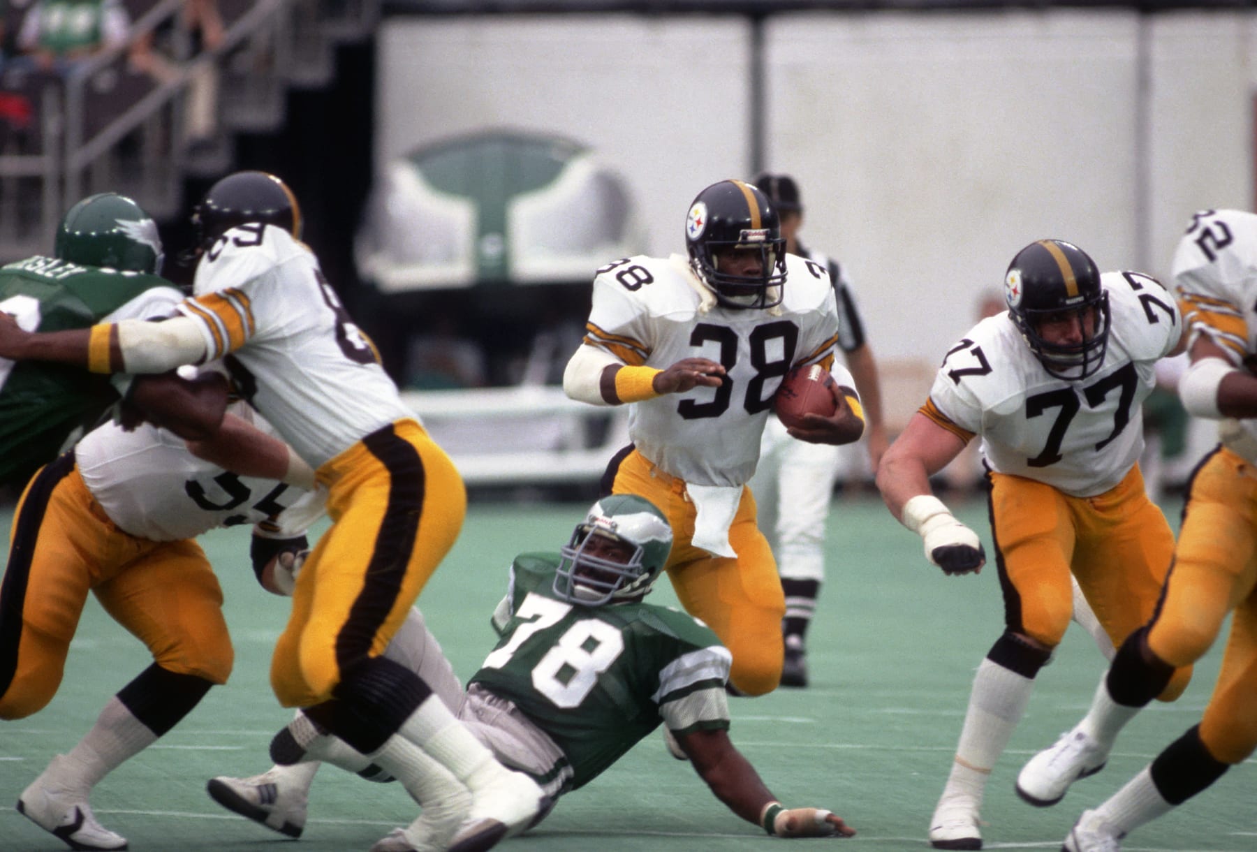 PHILADELPHIA, PA - AUGUST 15:  Running back Sidney Thornton #38 of the Pittsburgh Steelers runs with the football against defensive lineman Carl Hairston #78 of the Philadelphia Eagles as offensive lineman Steve Courson #77 blocks during a preseason game at Veterans Stadium on August 15, 1981 in Philadelphia, Pennsylvania.  The Eagles defeated the Steelers 36-20.  (Photo by George Gojkovich/Getty Images)
