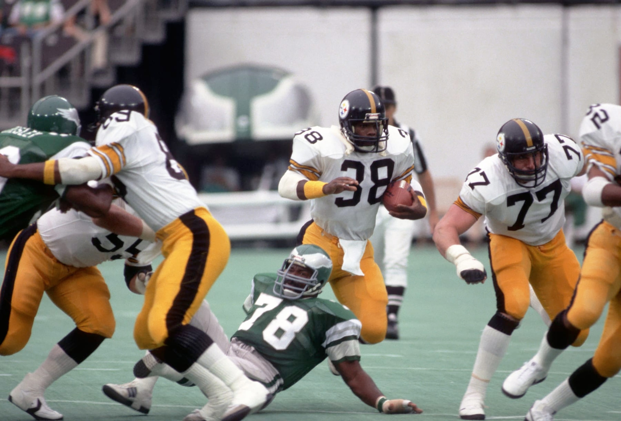 PHILADELPHIA, PA - AUGUST 15:  Running back Sidney Thornton #38 of the Pittsburgh Steelers runs with the football against defensive lineman Carl Hairston #78 of the Philadelphia Eagles as offensive lineman Steve Courson #77 blocks during a preseason game at Veterans Stadium on August 15, 1981 in Philadelphia, Pennsylvania.  The Eagles defeated the Steelers 36-20.  (Photo by George Gojkovich/Getty Images)