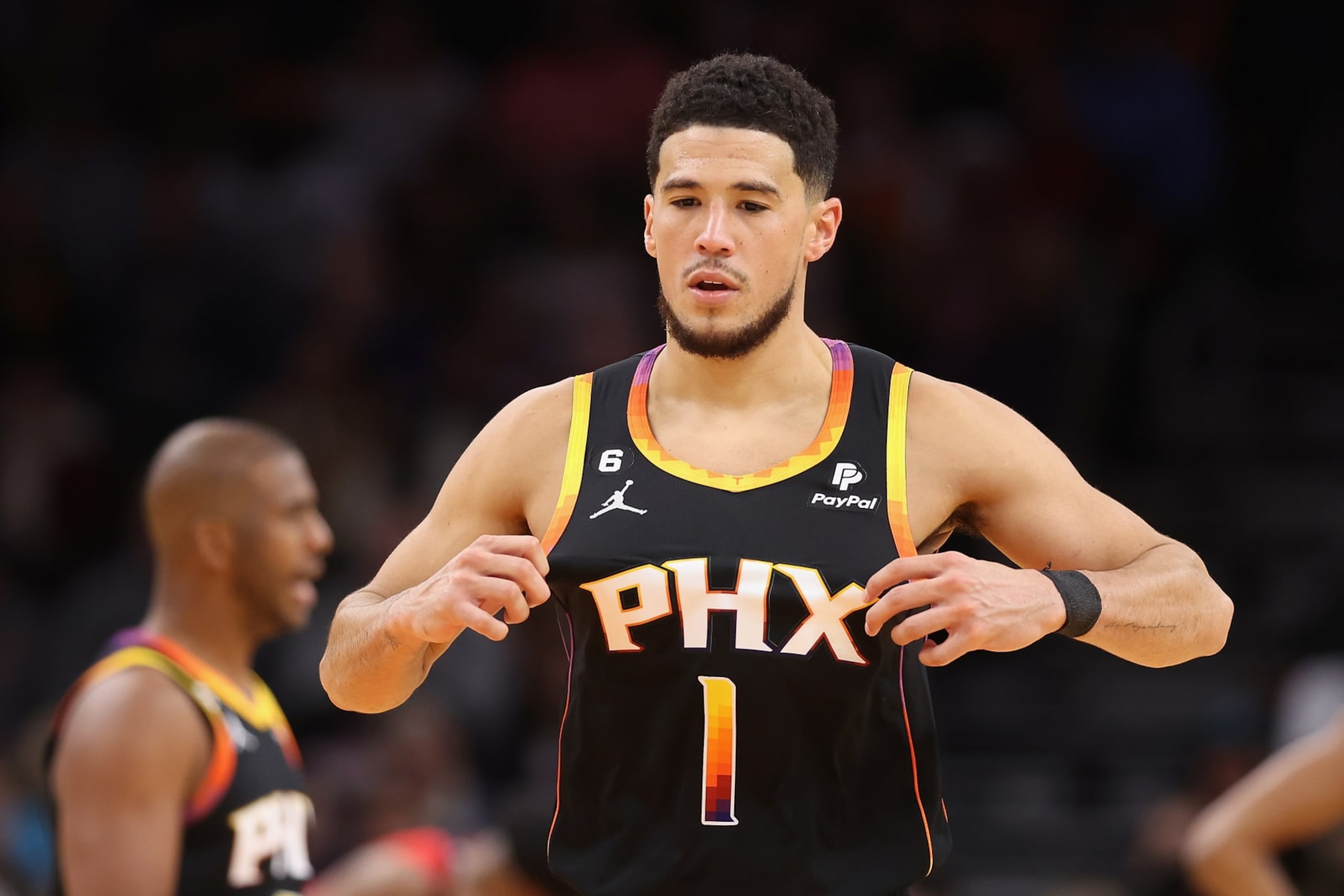 PHOENIX, ARIZONA - DECEMBER 17: Devin Booker #1 of the Phoenix Suns adjusts his jersey during the second half of the NBA game at Footprint Center on December 17, 2022 in Phoenix, Arizona. The Suns defeated the Pelicans 118-114.  NOTE TO USER: User expressly acknowledges and agrees that, by downloading and or using this photograph, User is consenting to the terms and conditions of the Getty Images License Agreement. (Photo by Christian Petersen/Getty Images)