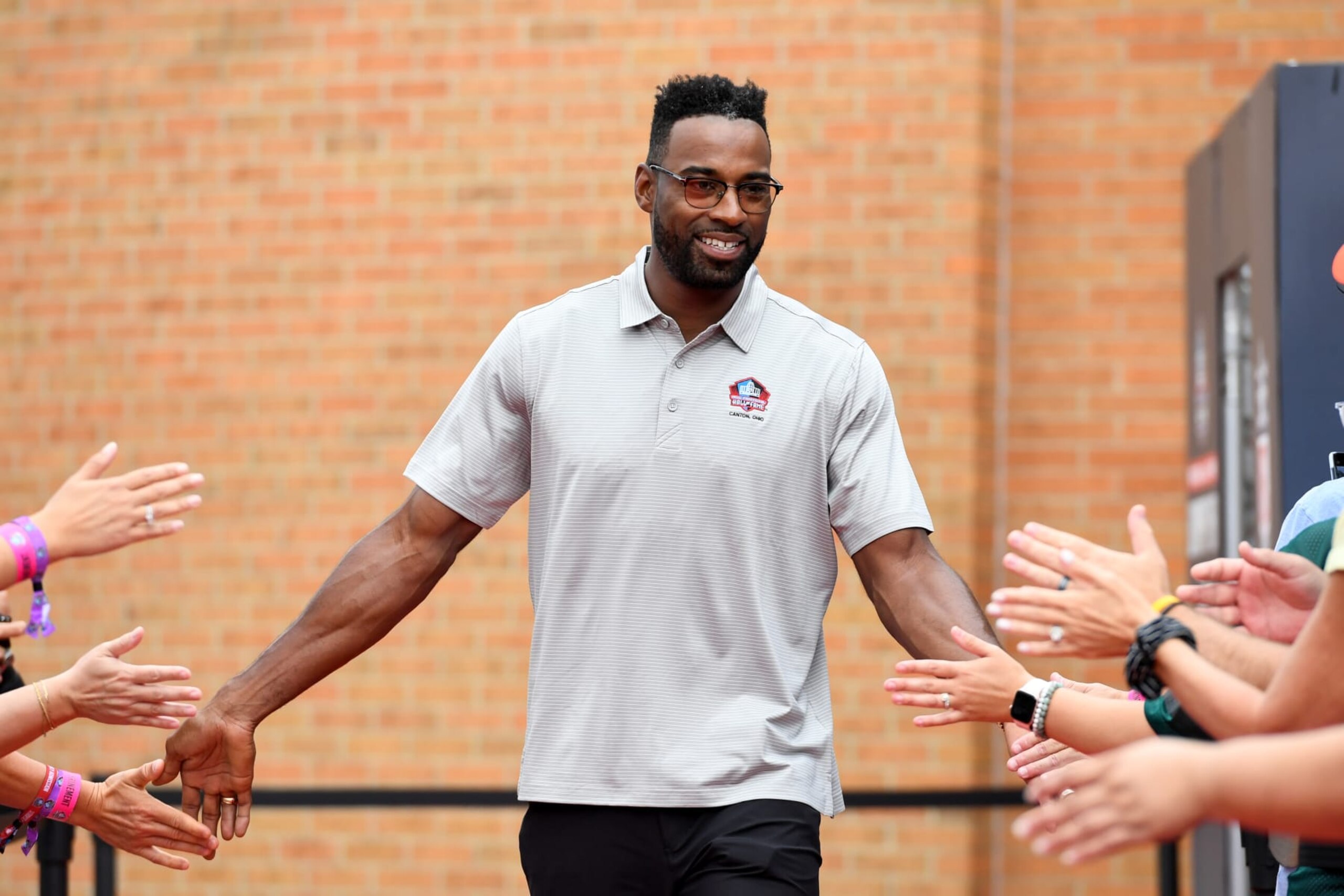 CANTON, OHIO - AUGUST 06: Hall of Fame wide receiver Calvin Johnson celebrates with fans as he is introduced prior to the 2022 Pro Hall of Fame Enshrinement Ceremony at Tom Benson Hall of Fame Stadium on August 06, 2022 in Canton, Ohio. (Photo by Nick Cammett/Getty Images)