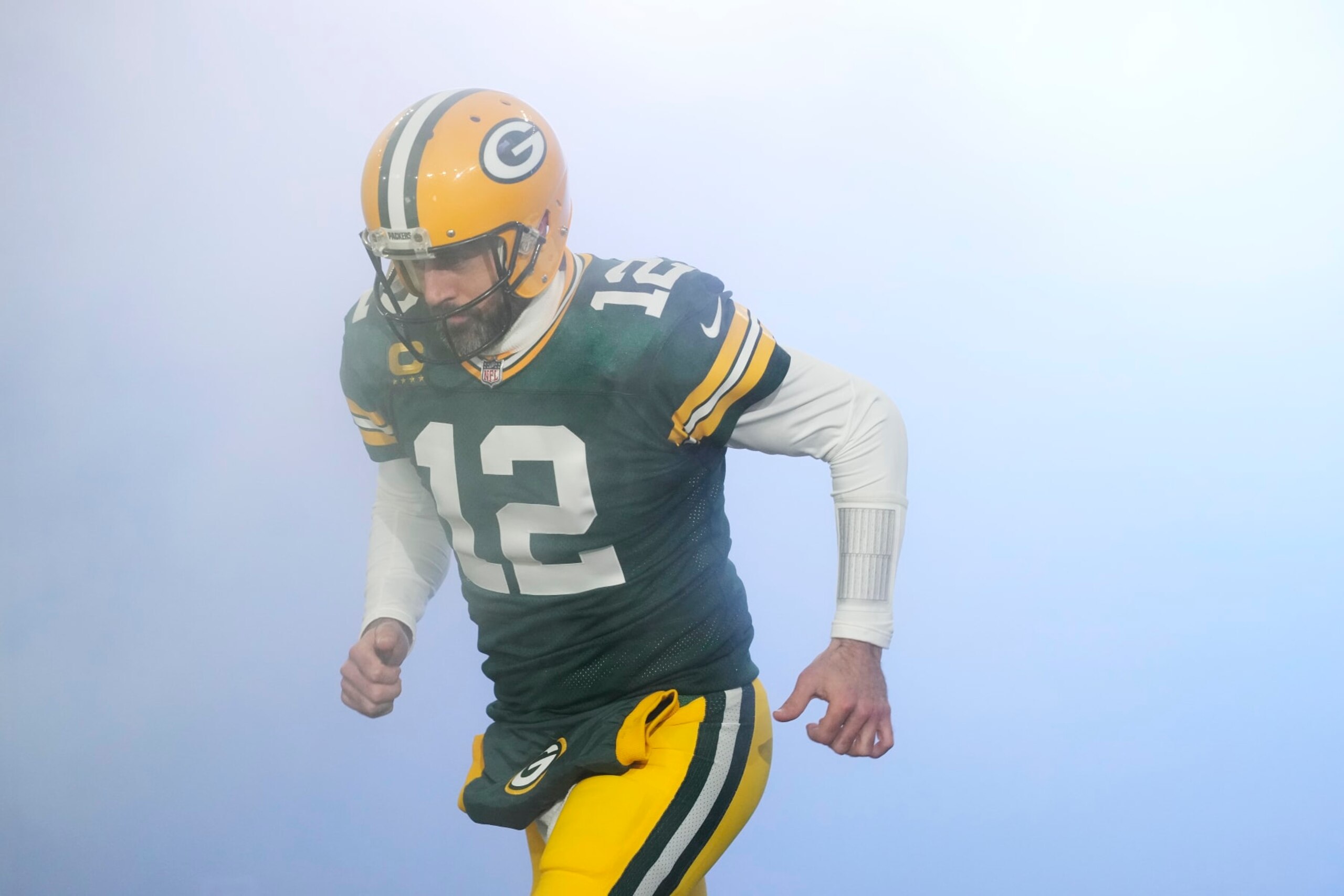 GREEN BAY, WISCONSIN - JANUARY 08: Aaron Rodgers #12 of the Green Bay Packers runs onto the field before a game against the Detroit Lions at Lambeau Field on January 08, 2023 in Green Bay, Wisconsin. (Photo by Patrick McDermott/Getty Images)