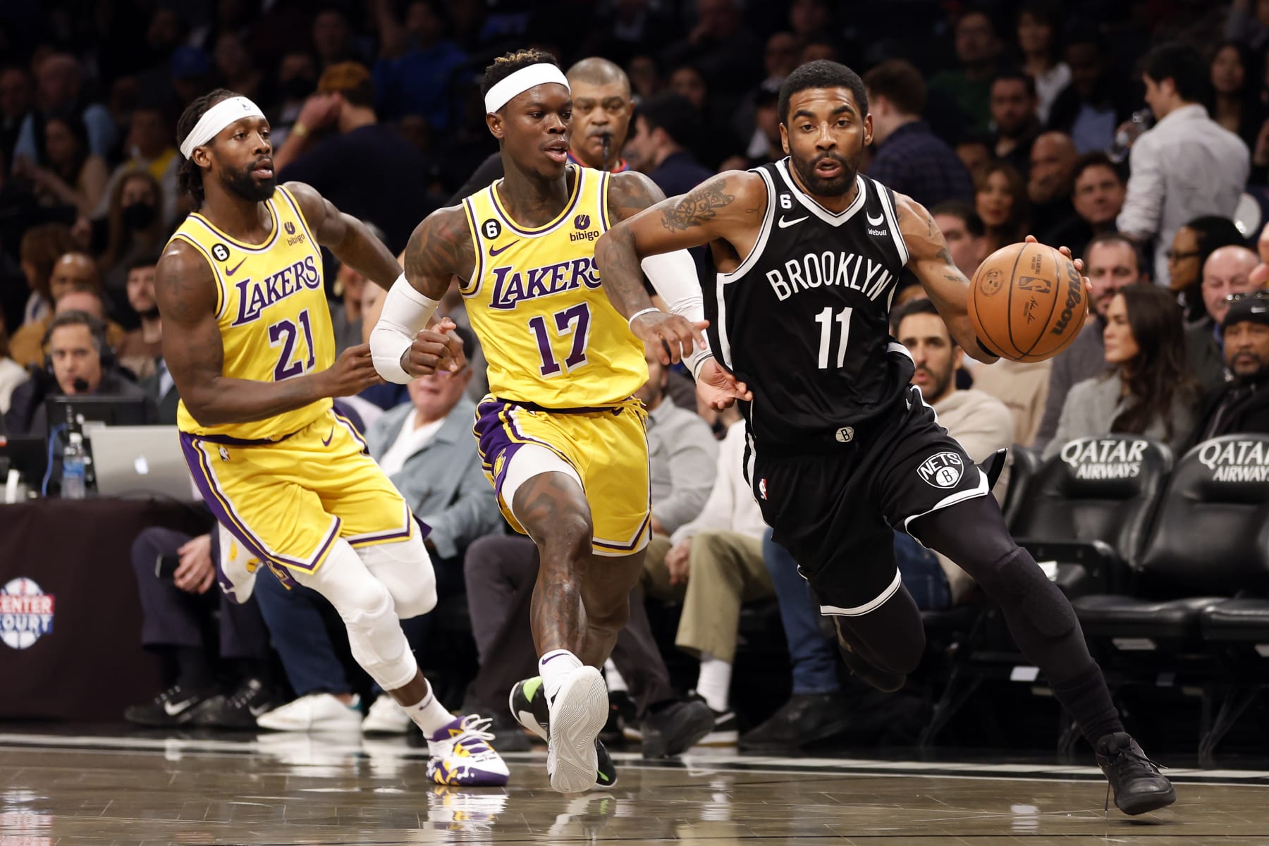 Kyrie Irving dribbles past Patrick Beverley and Dennis Schröder of the L.A. Lakers