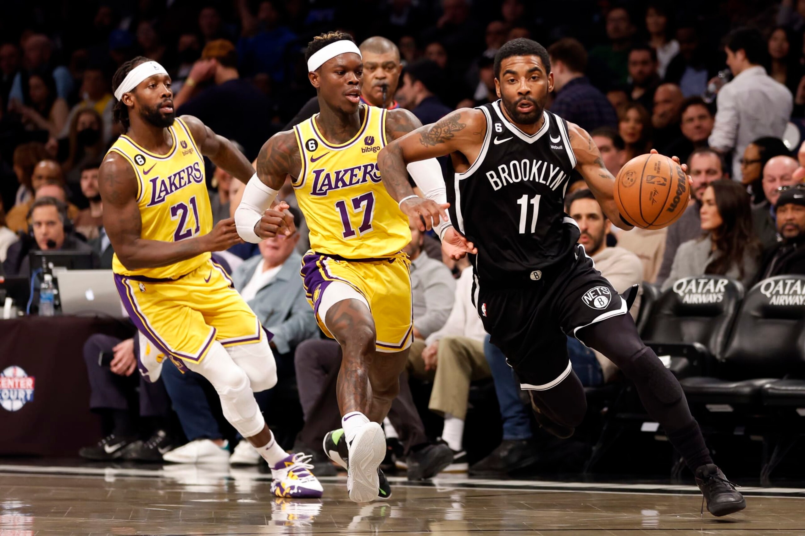 Kyrie Irving dribbles past Patrick Beverley and Dennis Schröder of the L.A. Lakers