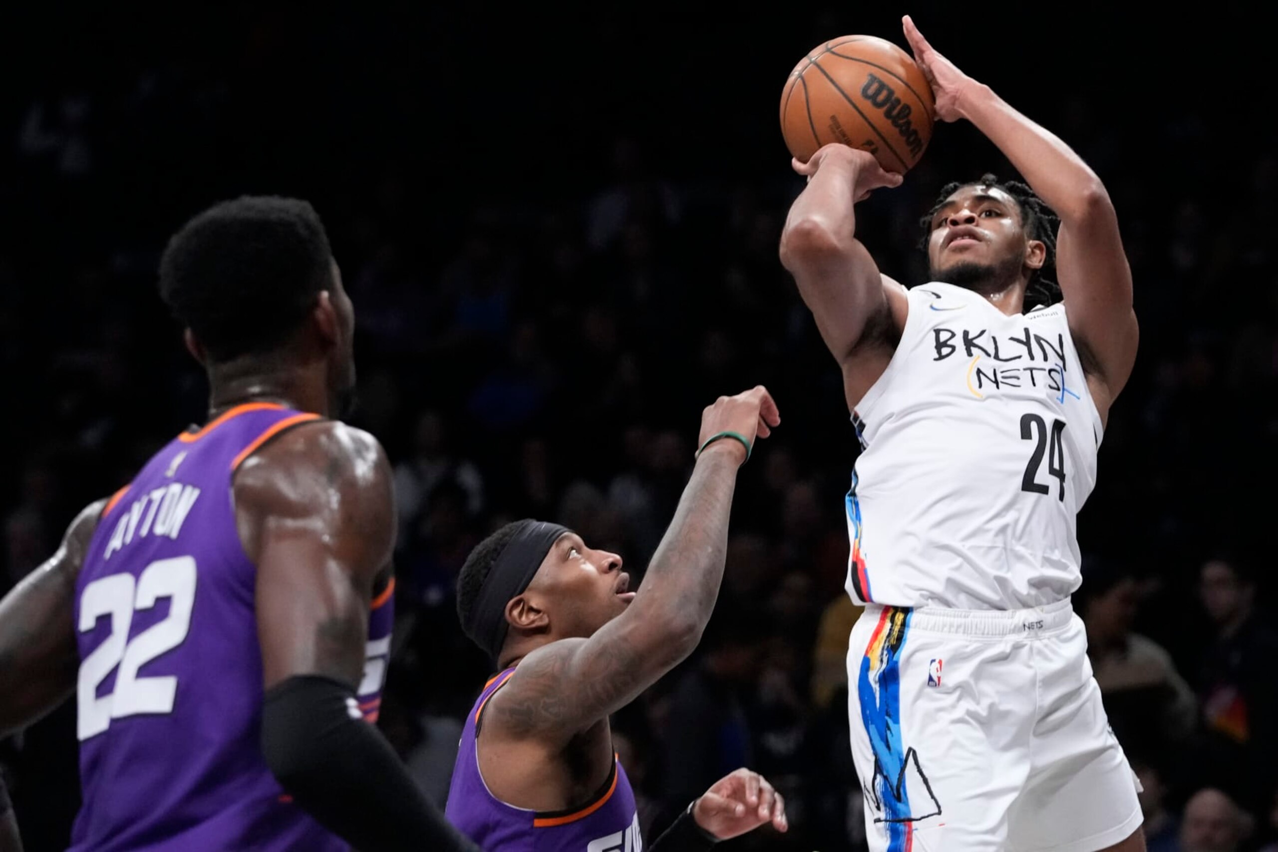 Brooklyn Nets guard Cam Thomas (24) shoots a three-point basket past Phoenix Suns center Deandre Ayton (22) and forward Torrey Craig during the first half of an NBA basketball game, Tuesday, Feb. 7, 2023, in New York. (AP Photo/Mary Altaffer)
