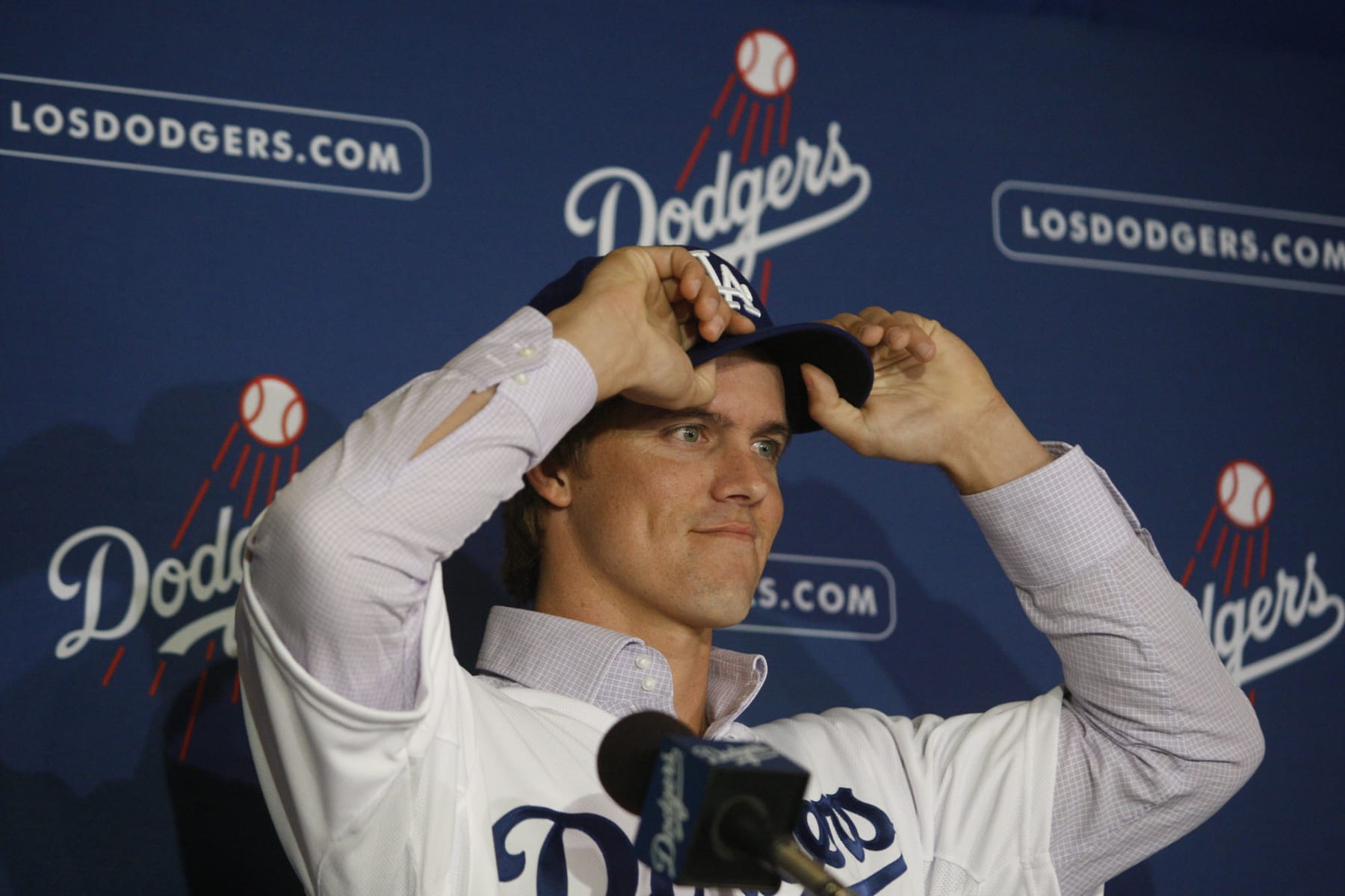 New Los Angeles Dodger pitcher Zack Greinke adjusts his baseball cap at a press conference announcing Greinke's signing at Dodger Stadium in Los Angeles on December 11, 2012. The right-handed, former Cy Young Award winner agreed to a six-year contract. Greinke, 29, will enter his 10th Major League season in 2013 after pitching for the Royals (2004-10), Brewers (2011-12) and Angels (2012) during the course of his careeer.  (Photo by Gary Friedman/Los Angeles Times via Getty Images)