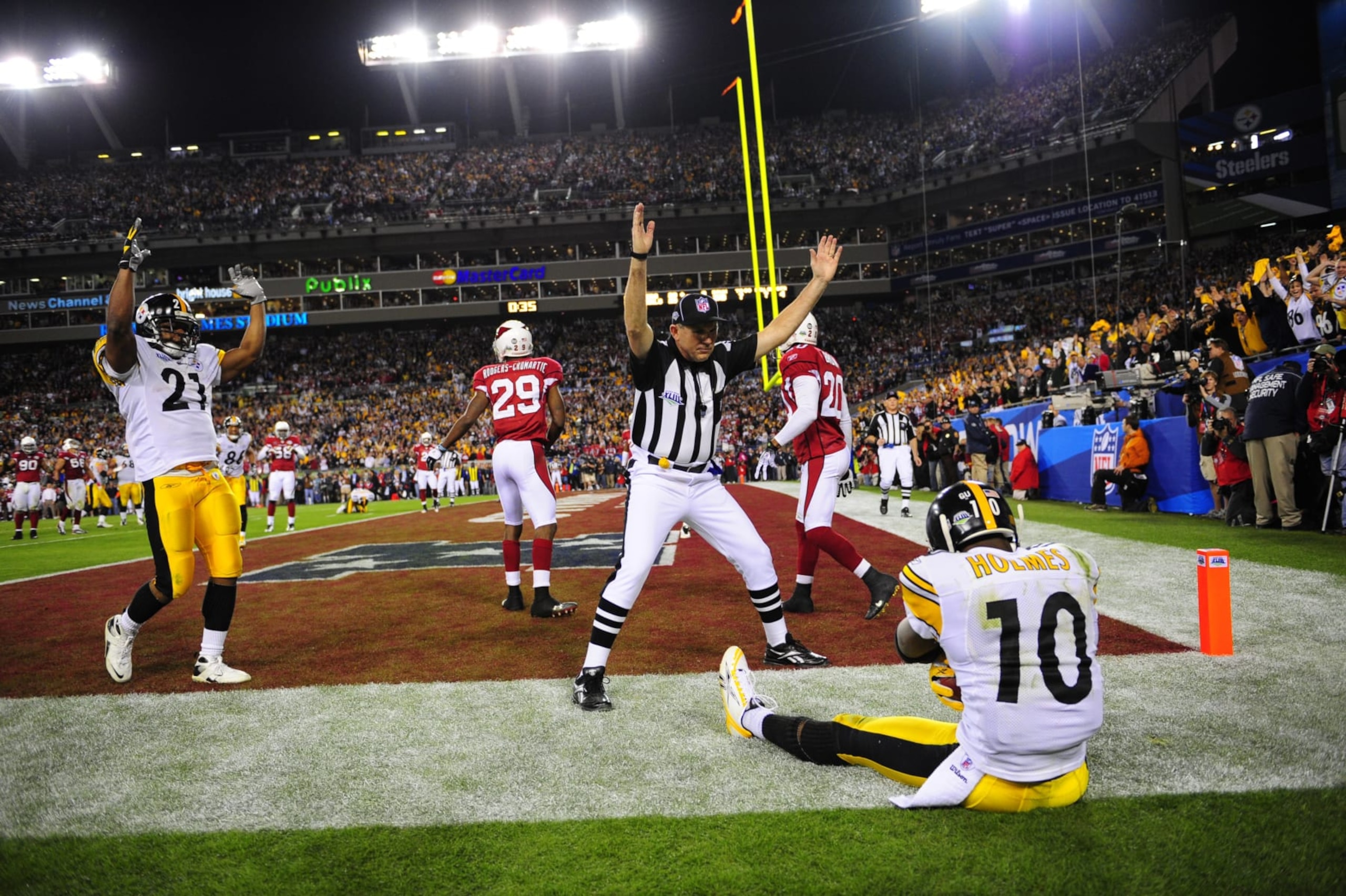 Football: Super Bowl XLIII: Pittsburgh Steelers Santonio Holmes (10) sitting out of bounds after making game winning touchdown catch vs Arizona Cardinals during 4th quarter. View of Steelers teammate Mewelde Moore (21) and referee, NFL field judge Greg Gautreaux (80), gesturing TD. Sequence. Tampa, FL 2/1/2009 CREDIT: Al Tielemans (Photo by Al Tielemans /Sports Illustrated via Getty Images) (Set Number: X81783 TK2 R2 F45 )