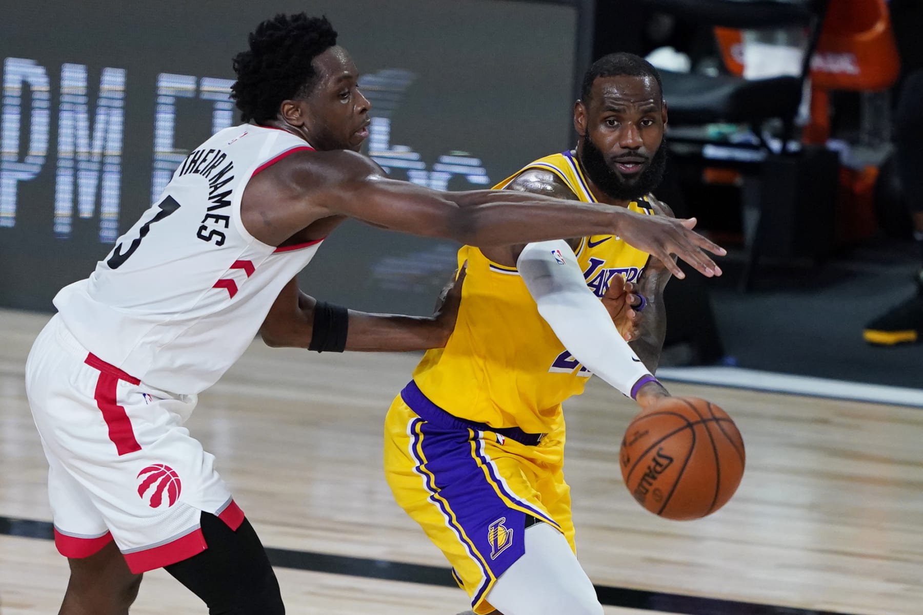LAKE BUENA VISTA, FLORIDA - AUGUST 01: LeBron James #23 of the Los Angeles Lakers passes the ball against OG Anunoby #3 of the Toronto Raptors during the second half of an NBA basketball game at The Arena in the ESPN Wide World Of Sports Complex on August 1, 2020 in Lake Buena Vista, Florida. NOTE TO USER: User expressly acknowledges and agrees that, by downloading and or using this photograph, User is consenting to the terms and conditions of the Getty Images License Agreement. (Photo by Ashley Landis - Pool/Getty Images)