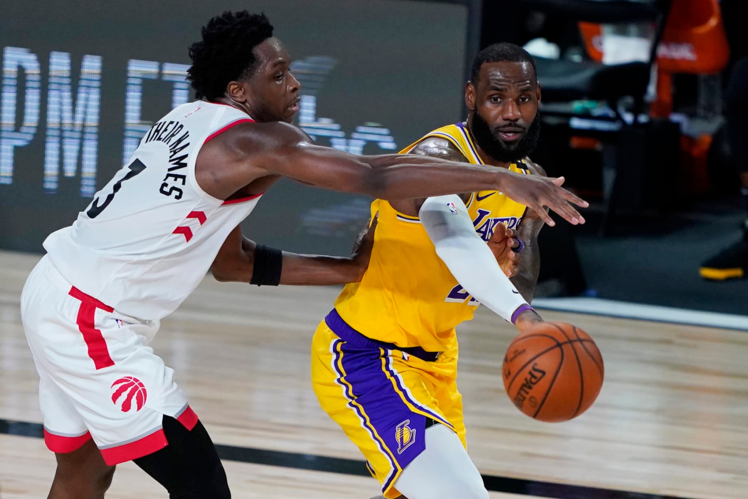 LAKE BUENA VISTA, FLORIDA - AUGUST 01: LeBron James #23 of the Los Angeles Lakers passes the ball against OG Anunoby #3 of the Toronto Raptors during the second half of an NBA basketball game at The Arena in the ESPN Wide World Of Sports Complex on August 1, 2020 in Lake Buena Vista, Florida. NOTE TO USER: User expressly acknowledges and agrees that, by downloading and or using this photograph, User is consenting to the terms and conditions of the Getty Images License Agreement. (Photo by Ashley Landis - Pool/Getty Images)