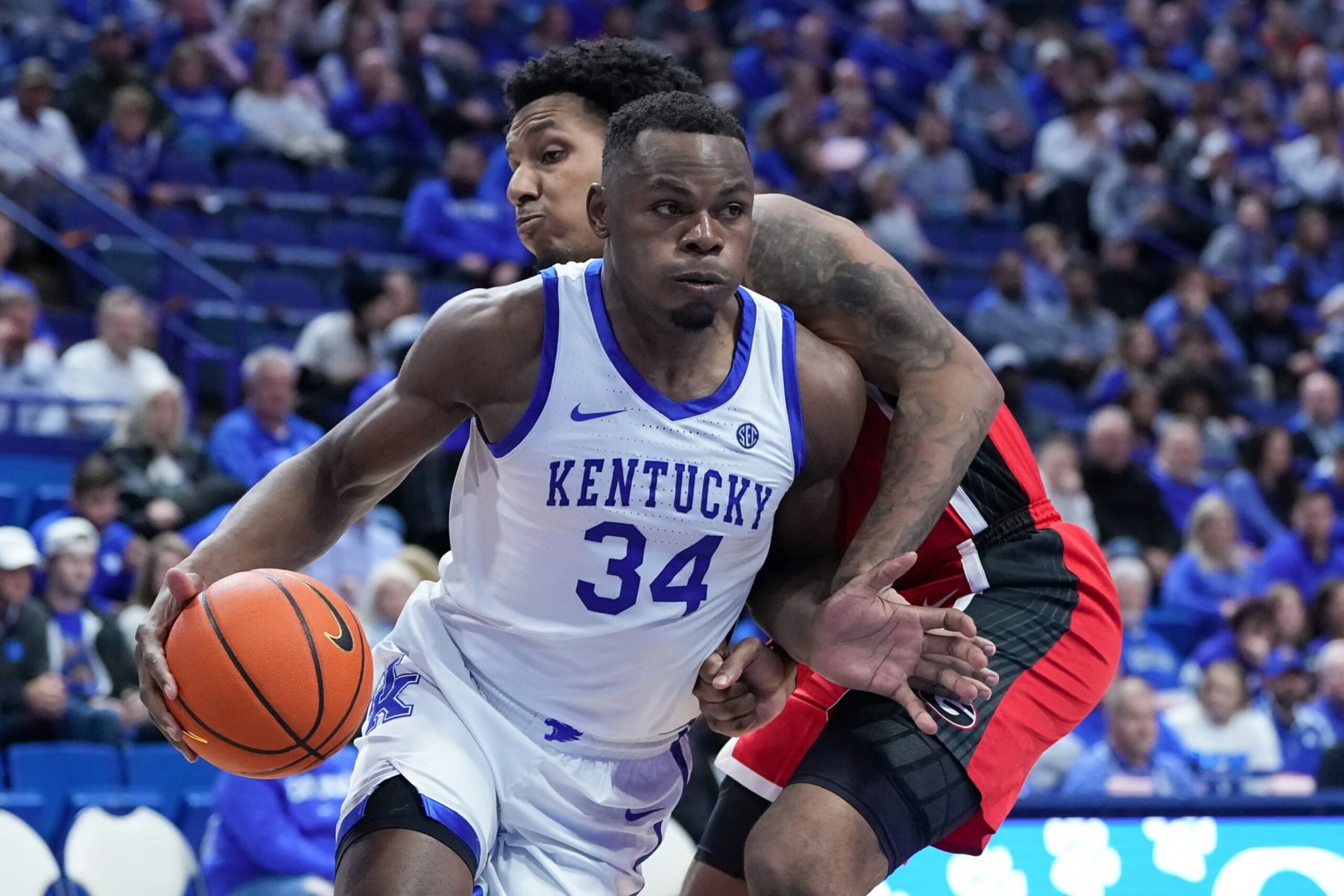 LEXINGTON, KENTUCKY - JANUARY 17: Oscar Tshiebwe #34 of the Kentucky Wildcats dribbles the ball while being guarded by Braelen Bridges #23 of the Georgia Bulldogs in the second half at Rupp Arena on January 17, 2023 in Lexington, Kentucky. (Photo by Dylan Buell/Getty Images)