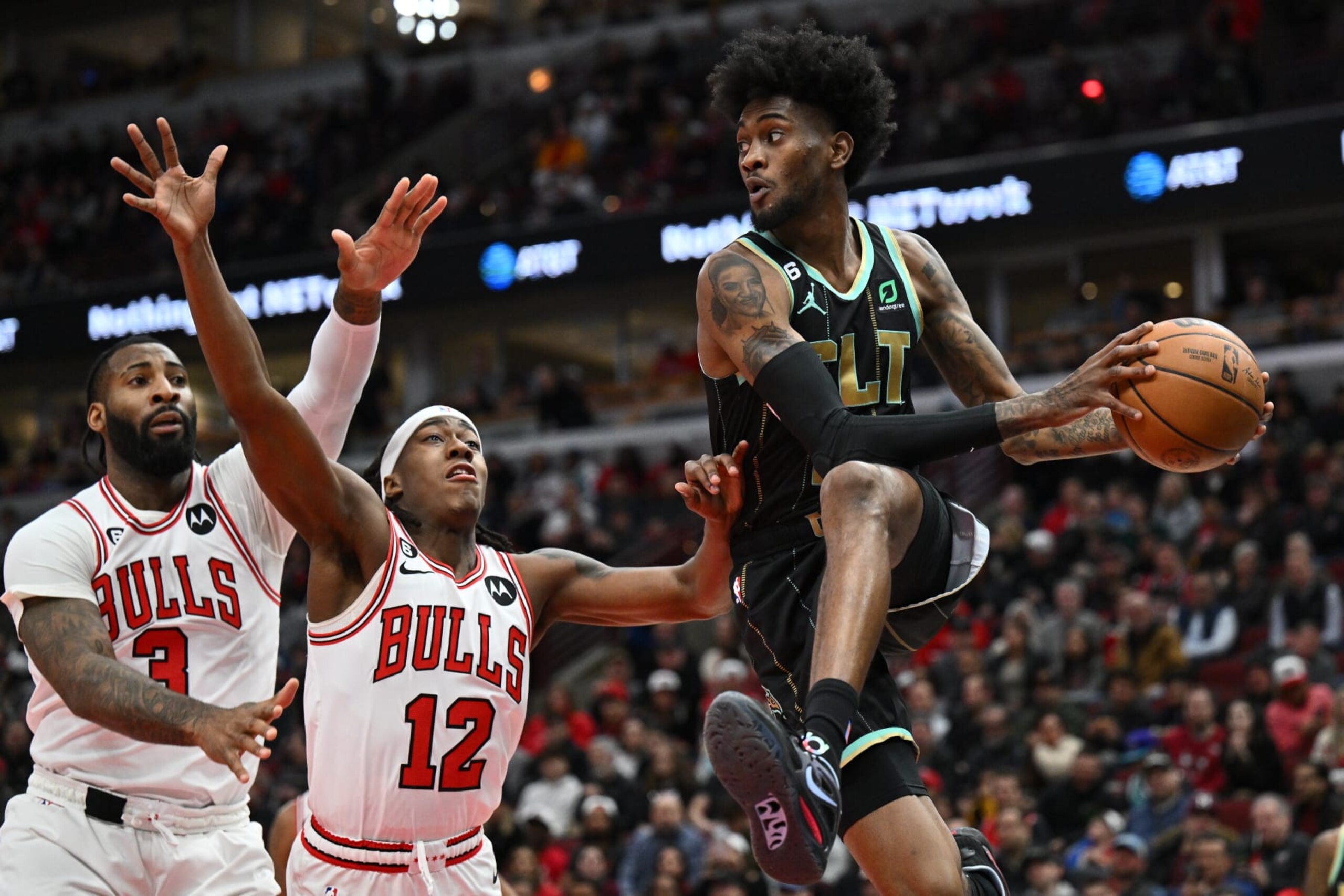 CHICAGO, ILLINOIS - FEBRUARY 02:  Jalen McDaniels #6 of the Charlotte Hornets controls the ball in front of Andre Drummond #3 of the Chicago Bulls and Ayo Dosunmu #12 on February 02, 2023 at United Center in Chicago, Illinois.   NOTE TO USER: User expressly acknowledges and agrees that, by downloading and or using this photograph, User is consenting to the terms and conditions of the Getty Images License Agreement.  (Photo by Jamie Sabau/Getty Images)
