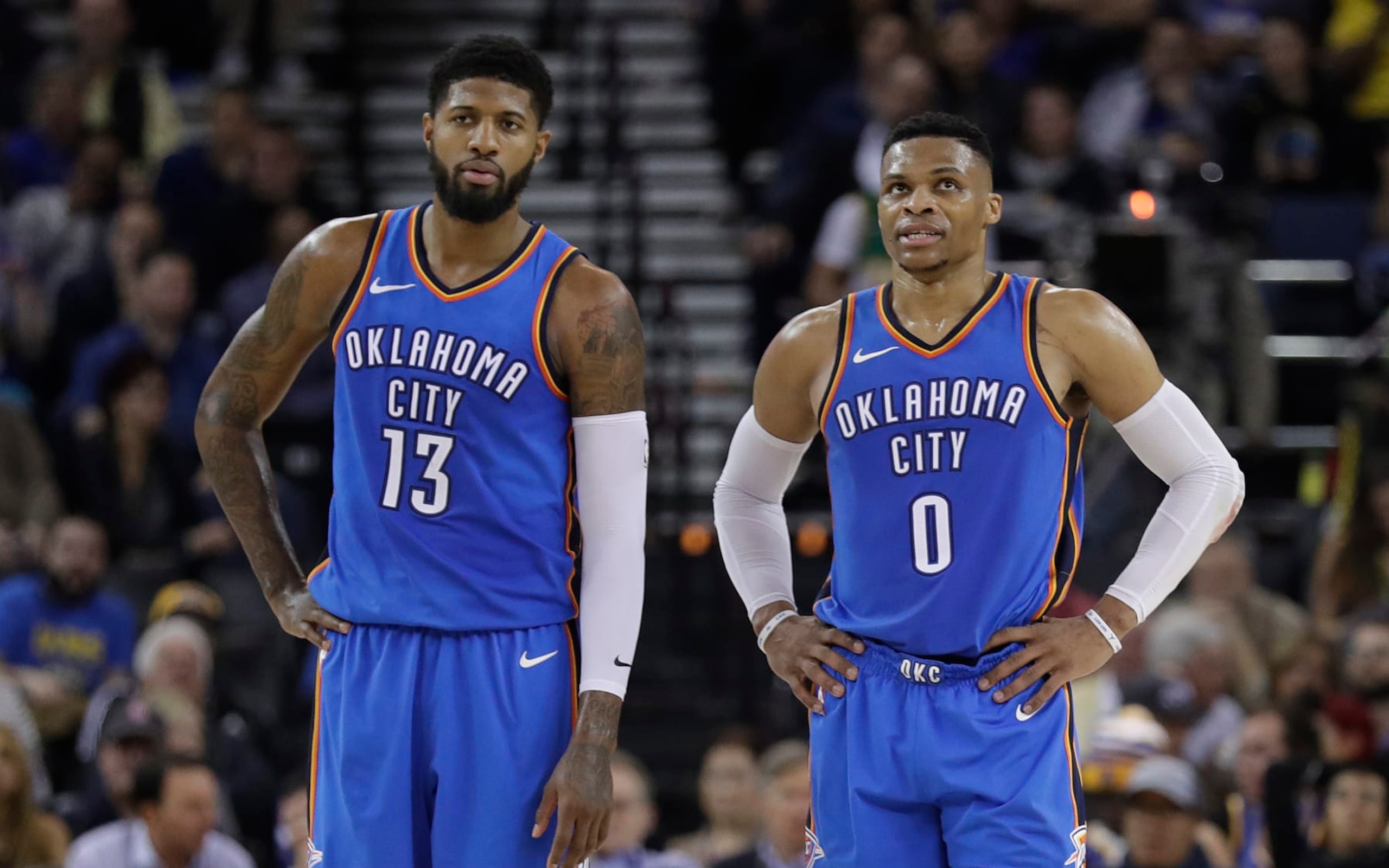 Oklahoma City Thunder's Russell Westbrook (0) stands next to teammate Paul George (13) during the first half of an NBA basketball game against the Golden State Warriors Tuesday, Feb. 6, 2018, in Oakland, Calif. (AP Photo/Marcio Jose Sanchez)