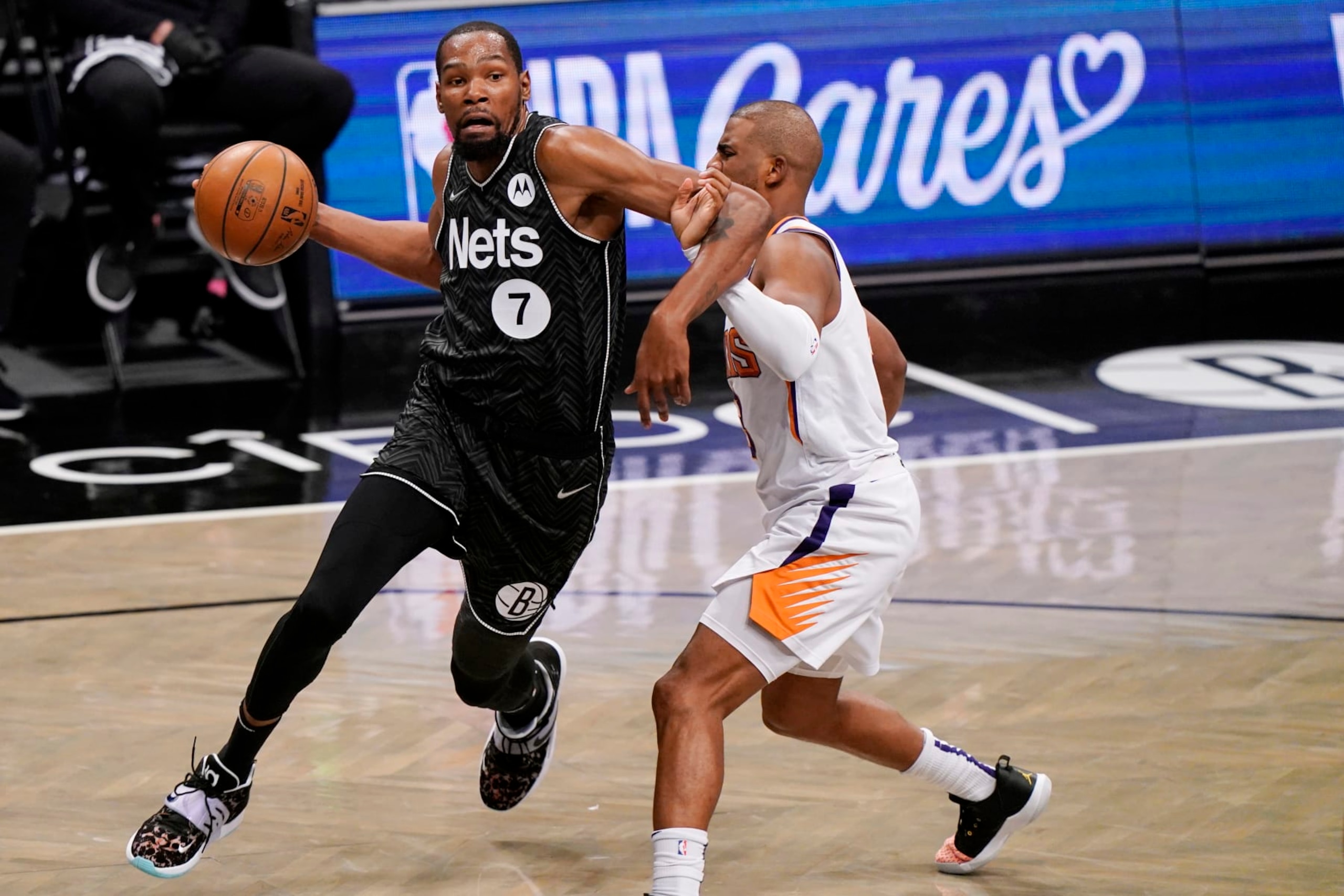 Brooklyn Nets forward Kevin Durant (7) becomes entangled with Phoenix Suns guard Chris Paul during the third quarter of an NBA basketball game, Sunday, April 25, 2021, in New York. (AP Photo/Kathy Willens)