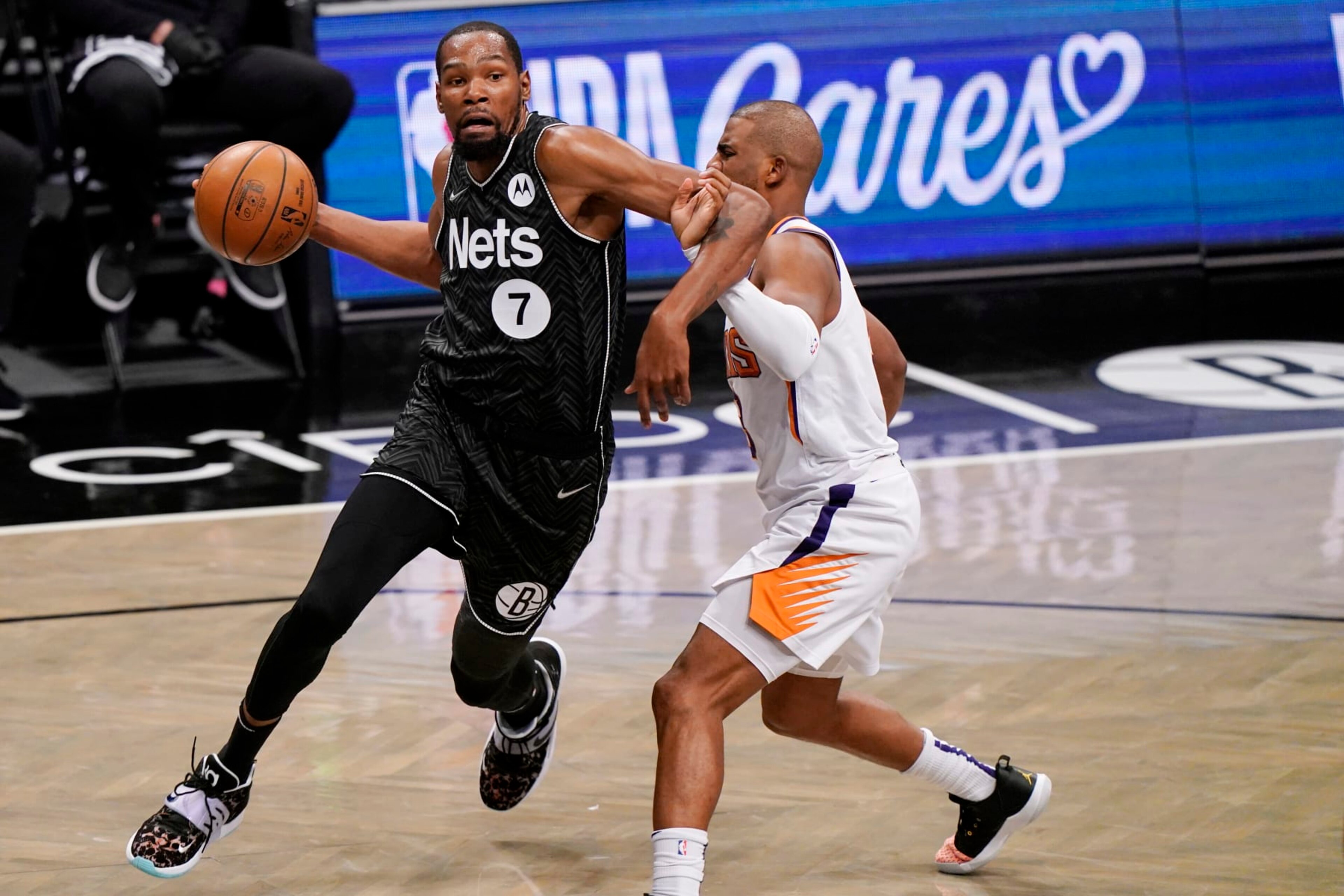 Brooklyn Nets forward Kevin Durant (7) becomes entangled with Phoenix Suns guard Chris Paul during the third quarter of an NBA basketball game, Sunday, April 25, 2021, in New York. (AP Photo/Kathy Willens)