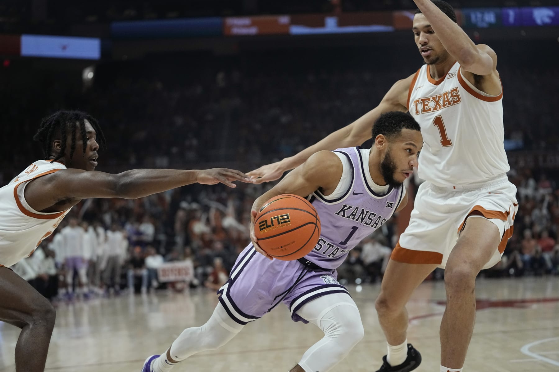 Kansas State guard Markquis Nowell, center, drives to the basket against Texas guard Marcus Carr, left, and forward Dylan Disu, right, during the first half of an NCAA college basketball game in Austin, Texas, Tuesday, Jan. 3, 2023. (AP Photo/Eric Gay)