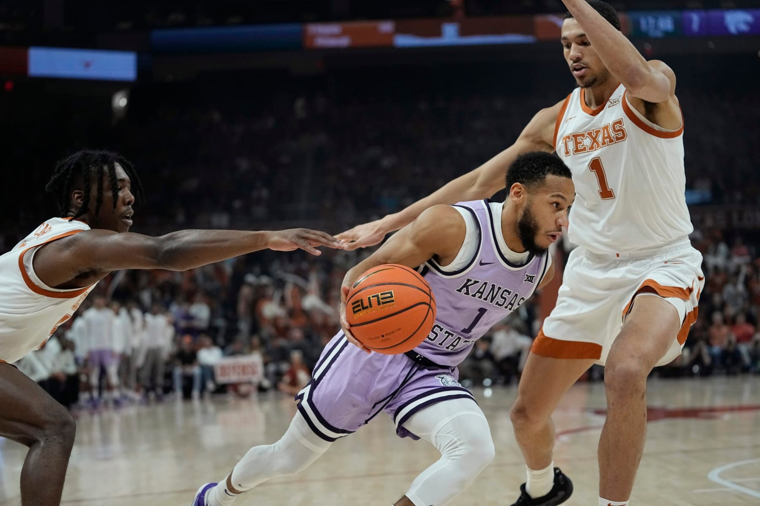 Kansas State guard Markquis Nowell, center, drives to the basket against Texas guard Marcus Carr, left, and forward Dylan Disu, right, during the first half of an NCAA college basketball game in Austin, Texas, Tuesday, Jan. 3, 2023. (AP Photo/Eric Gay)