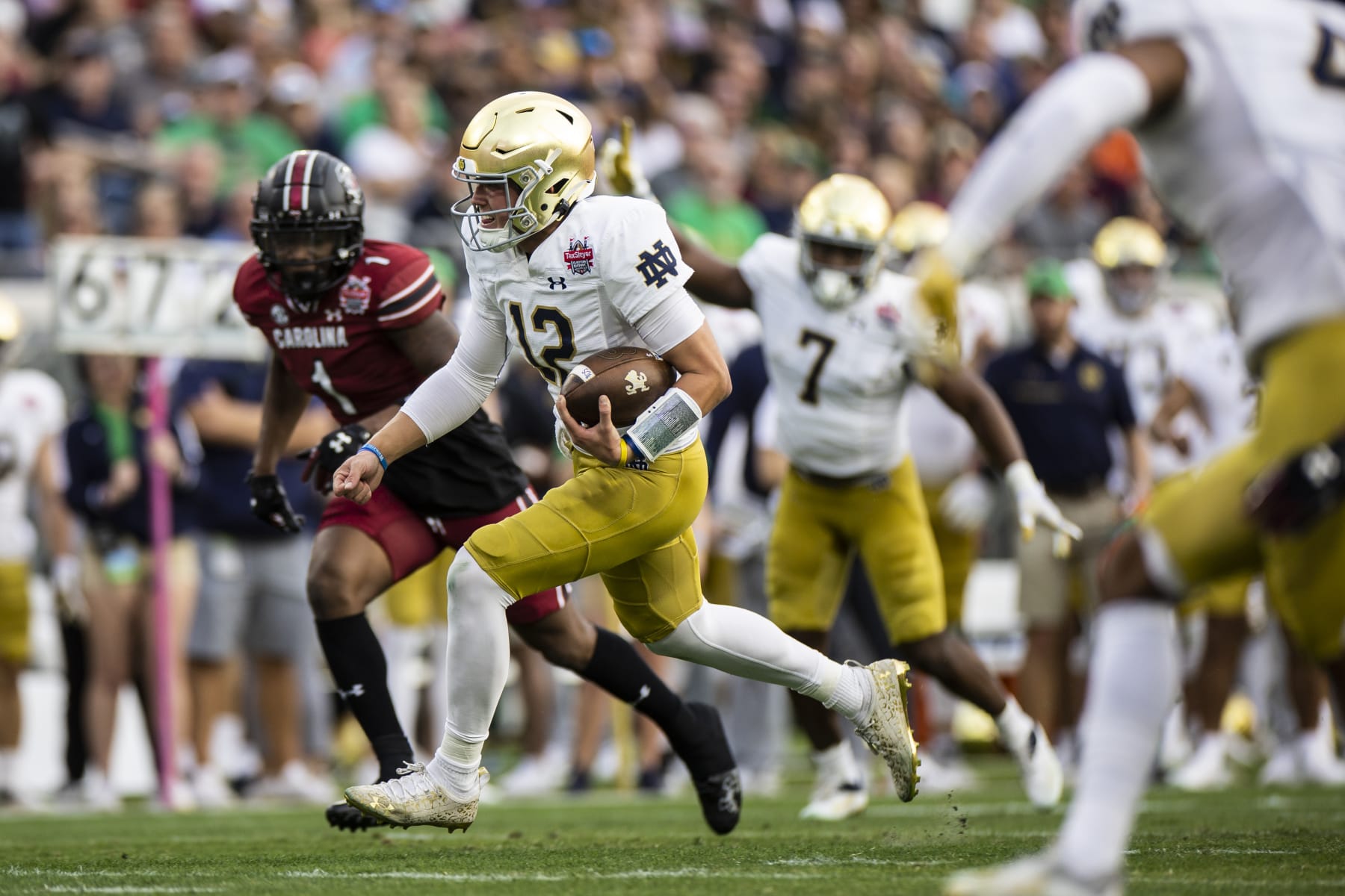 JACKSONVILLE, FLORIDA - DECEMBER 30: Tyler Buchner #12 of the Notre Dame Fighting Irish rushes for a touchdown during the 1st quarter of the TaxSlayer Gator Bowl against the South Carolina Gamecocks at TIAA Bank Field on December 30, 2022 in Jacksonville, Florida. (Photo by James Gilbert/Getty Images)