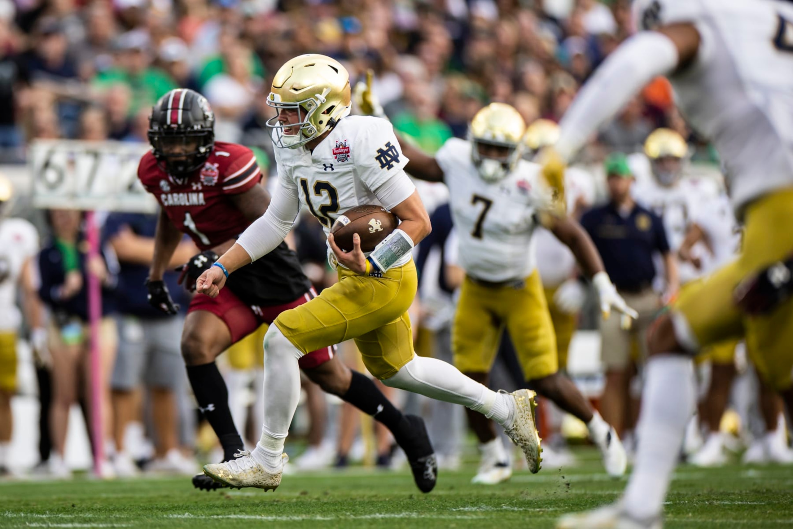JACKSONVILLE, FLORIDA - DECEMBER 30: Tyler Buchner #12 of the Notre Dame Fighting Irish rushes for a touchdown during the 1st quarter of the TaxSlayer Gator Bowl against the South Carolina Gamecocks at TIAA Bank Field on December 30, 2022 in Jacksonville, Florida. (Photo by James Gilbert/Getty Images)