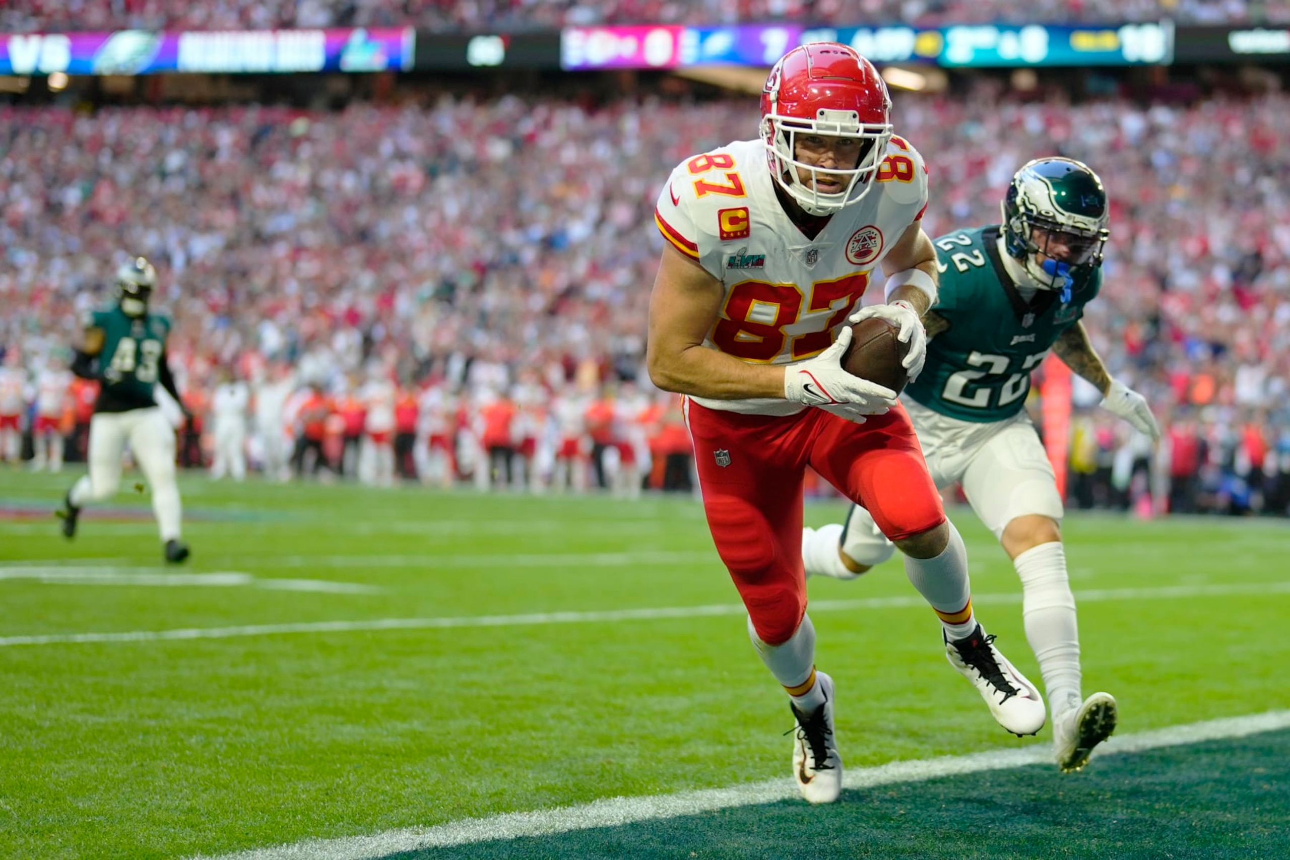 Kansas City Chiefs tight end Travis Kelce (87) scores a touchdown ahead of Philadelphia Eagles safety Marcus Epps (22) during the first half of the NFL Super Bowl 57 football game between the Kansas City Chiefs and the Philadelphia Eagles, Sunday, Feb. 12, 2023, in Glendale, Ariz. (AP Photo/Matt Slocum)