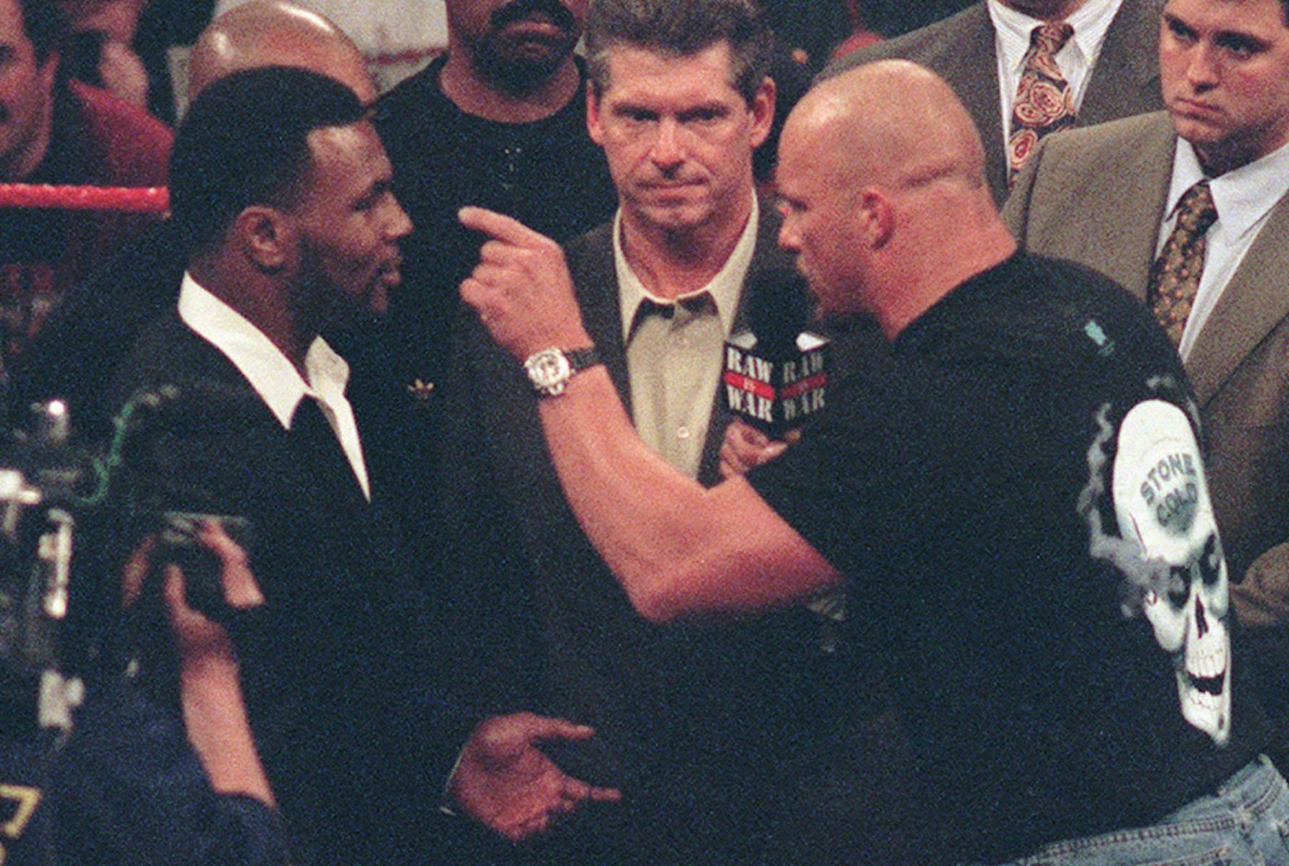 Stone Cold Steve Austin, right, points a finger and challenges Mike Tyson, left, to a professional wrestling match as Vince McMahon, center, CEO of the World Wrestling Federation listens in at WWF's Raw is War show on Monday, Jan. 19, 1998, in Fresno, Calif. Tyson had appeared as a guest of McMahon's and was about to announce Tyson's role as a guest referee for Wrestlemania XIV, an upcoming WWF event in Boston this March, when Stone Cold Steve Austin joined the group in the ring for the unexpected challenge. (AP Photo/Eric Paul Zamora) Stone Cold Steve Austin, right, points a finger and challenges Mike Tyson, left, to a professional wrestling match as Vince McMahon, center, CEO of the World Wrestling Federation listens in at WWF's Raw is War show on Monday, Jan. 19, 1998, in Fresno, Calif. Tyson had appeared as a guest of McMahon's and was about to announce Tyson's role as a guest referee for Wrestlemania XIV, an upcoming WWF event in Boston this March, when Stone Cold Steve Austin joined the group in the ring for the unexpected challenge. (AP Photo/Eric Paul Zamora)