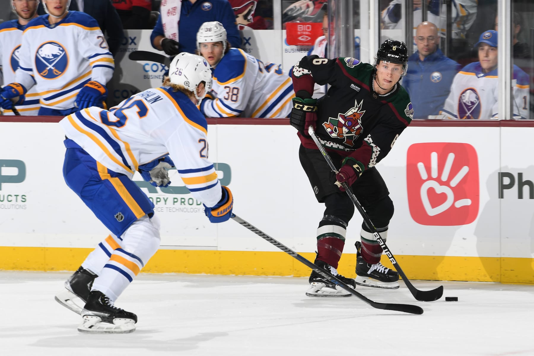 TEMPE, ARIZONA - DECEMBER 17: Jakob Chychrun #6 of the Arizona Coyotes skates with the puck while being defended by Rasmus Dahlin #26 of the Buffalo Sabres during the first period at Mullett Arena on December 17, 2022 in Tempe, Arizona. (Photo by Norm Hall/NHLI via Getty Images)