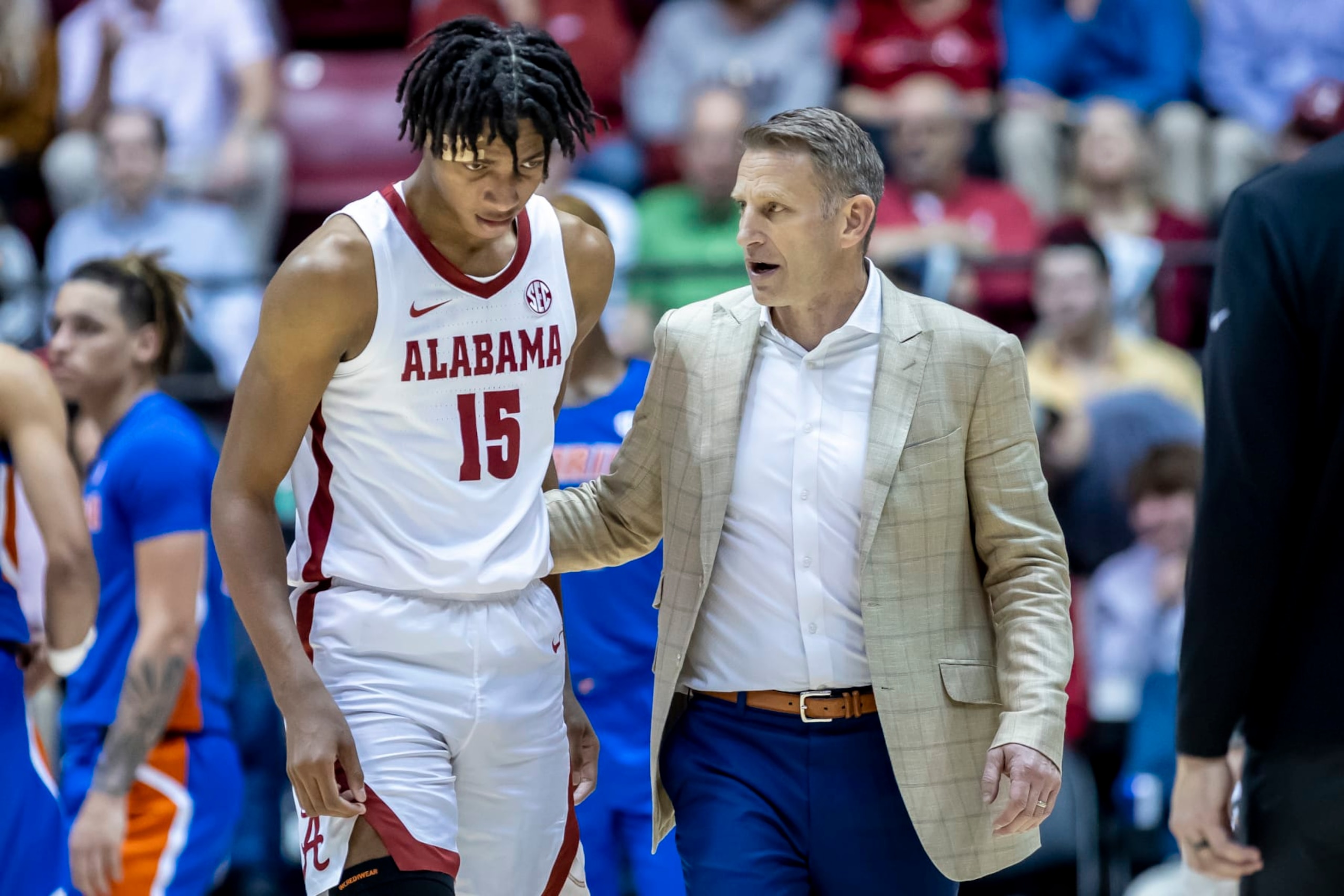 Alabama forward Noah Clowney (15) heads off the court with coach Nate Oats after getting shaken up in a collision during the second half of the team's NCAA college basketball game against Florida, Wednesday, Feb. 8, 2023, in Tuscaloosa, Ala. (AP Photo/Vasha Hunt)