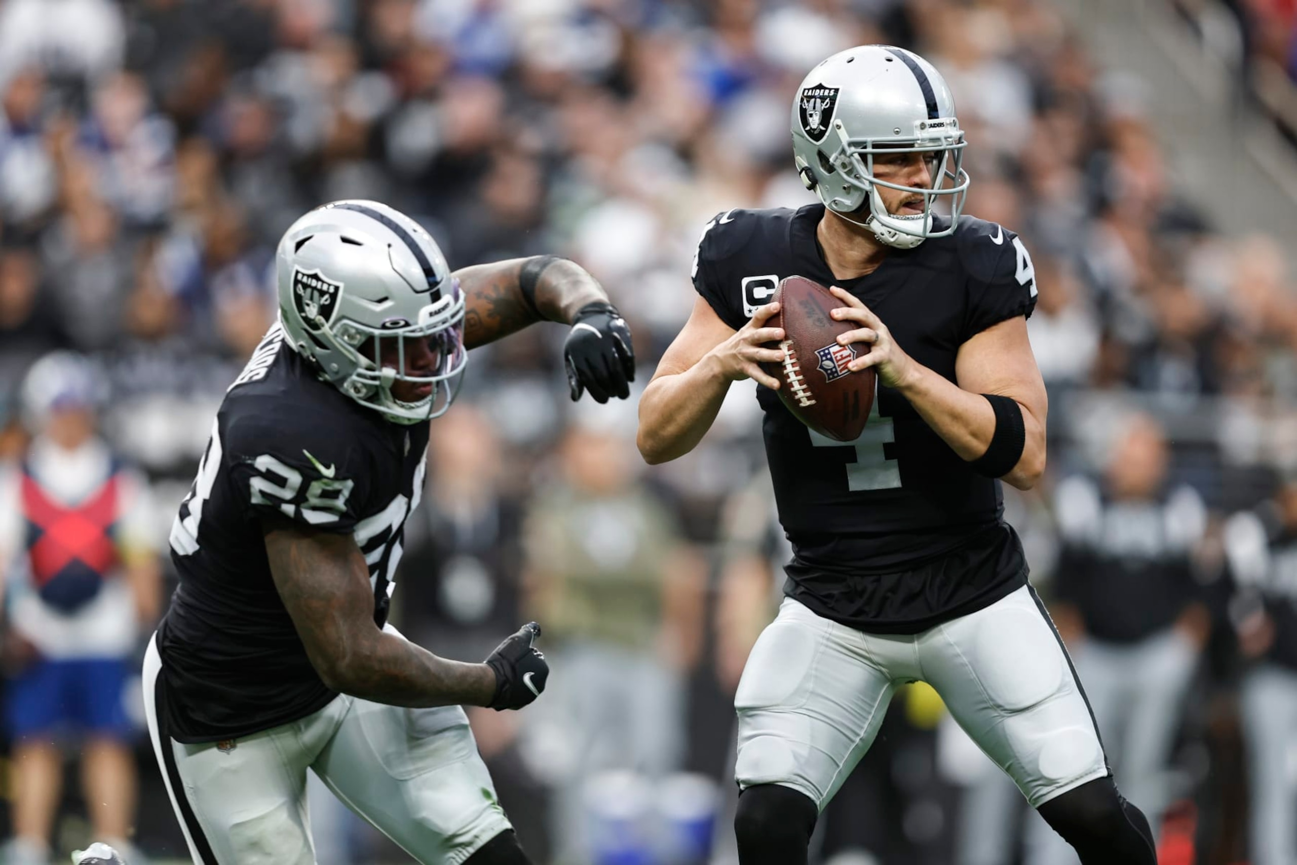 LAS VEGAS, NEVADA - NOVEMBER 13: Derek Carr #4 of the Las Vegas Raiders fakes the hand off to Josh Jacobs #28 of the Las Vegas Raiders and looks to pass during an NFL game between the Las Vegas Raiders and the Indianapolis Colts at Allegiant Stadium on November 13, 2022 in Las Vegas, Nevada. (Photo by Michael Owens/Getty Images)