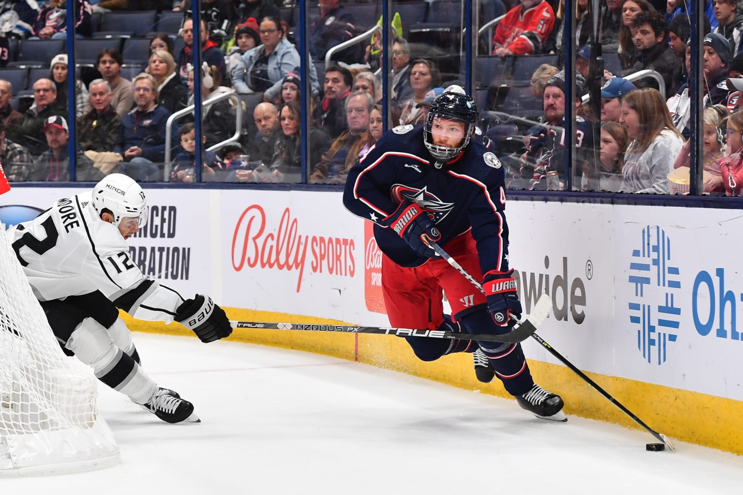 COLUMBUS, OHIO - DECEMBER 11: Vladislav Gavrikov #4 of the Columbus Blue Jackets skates with the puck as Trevor Moore #12 of the Los Angeles Kings defends during the first period of a game at Nationwide Arena on December 11, 2022 in Columbus, Ohio. (Photo by Ben Jackson/NHLI via Getty Images) COLUMBUS, OHIO - DECEMBER 11: Vladislav Gavrikov #4 of the Columbus Blue Jackets skates with the puck as Trevor Moore #12 of the Los Angeles Kings defends during the first period of a game at Nationwide Arena on December 11, 2022 in Columbus, Ohio. (Photo by Ben Jackson/NHLI via Getty Images)