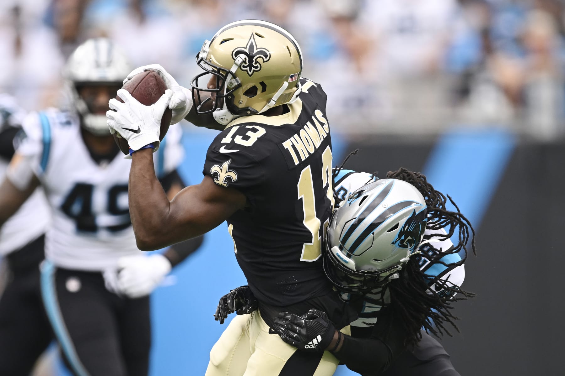 CHARLOTTE, NORTH CAROLINA - SEPTEMBER 25: Michael Thomas #13 of the New Orleans Saints catches a pass while being tackled by Donte Jackson #26 of the Carolina Panthers during the first quarter at Bank of America Stadium on September 25, 2022 in Charlotte, North Carolina. (Photo by Eakin Howard/Getty Images)
