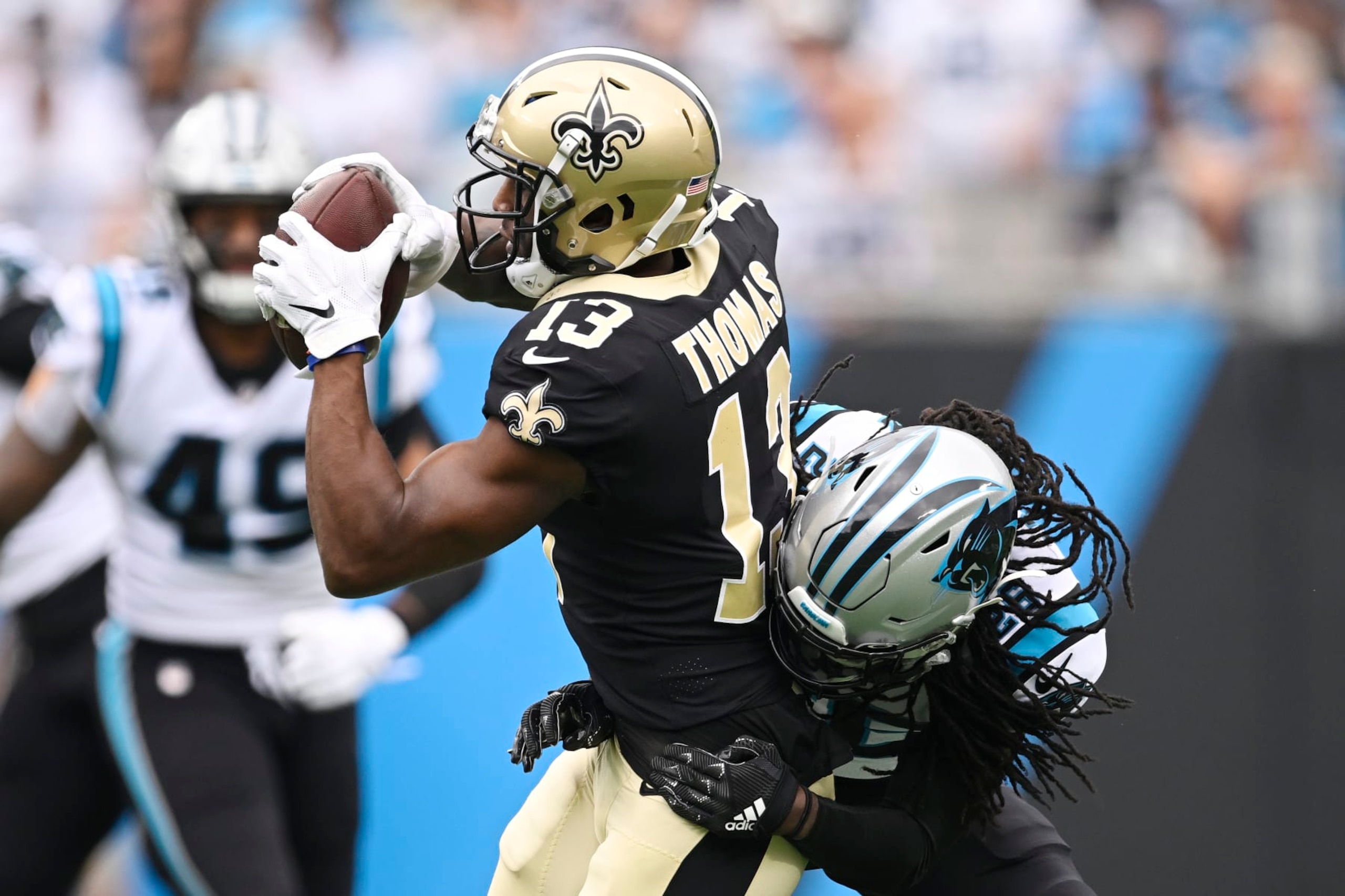 CHARLOTTE, NORTH CAROLINA - SEPTEMBER 25: Michael Thomas #13 of the New Orleans Saints catches a pass while being tackled by Donte Jackson #26 of the Carolina Panthers during the first quarter at Bank of America Stadium on September 25, 2022 in Charlotte, North Carolina. (Photo by Eakin Howard/Getty Images)