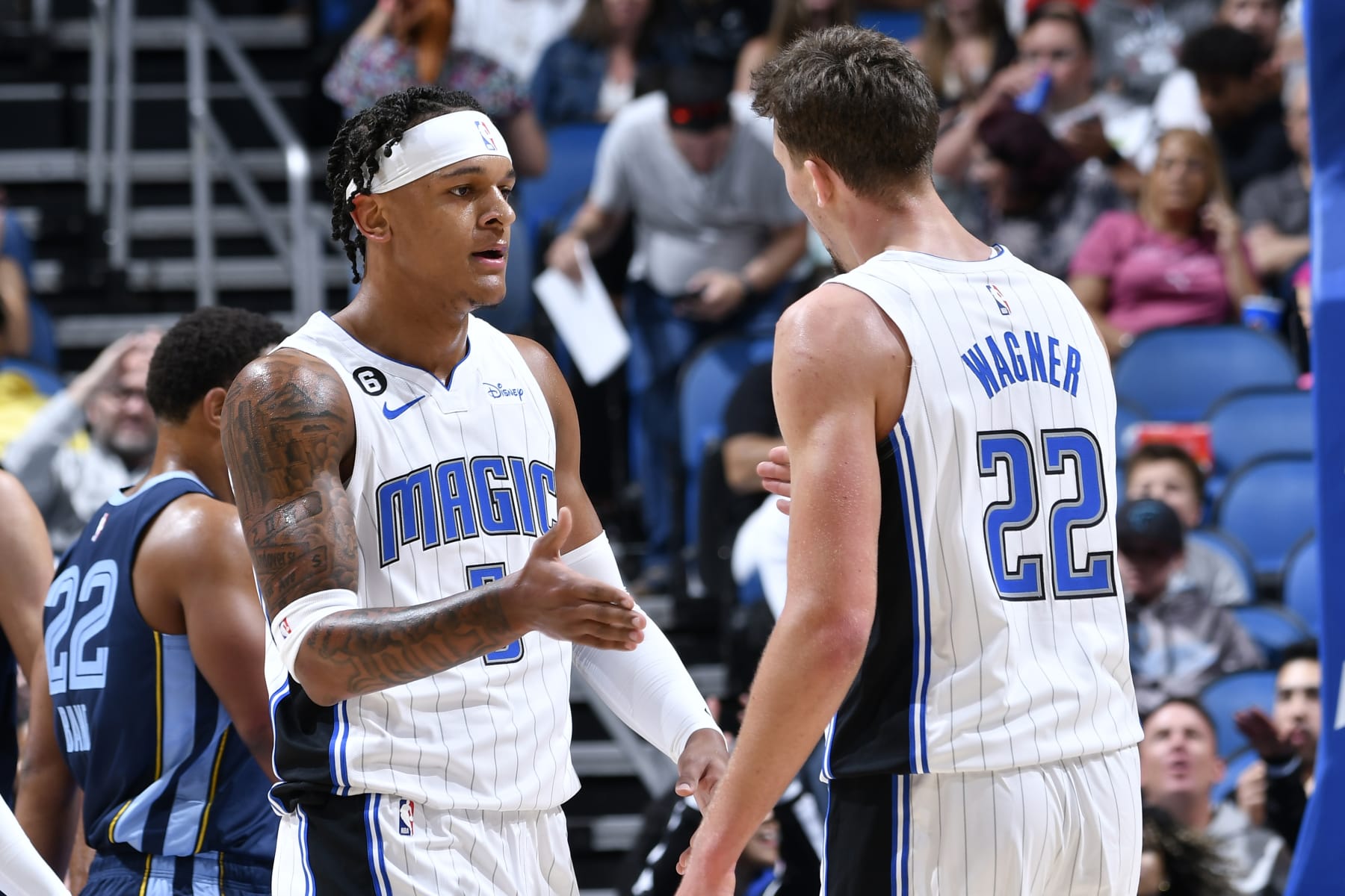 ORLANDO, FL - OCTOBER 11: Paolo Banchero #5 high fives Franz Wagner #22 of the Orlando Magic during the game against the Memphis Grizzlies on October 11, 2022 at Amway Center in Orlando, Florida. NOTE TO USER: User expressly acknowledges and agrees that, by downloading and or using this photograph, User is consenting to the terms and conditions of the Getty Images License Agreement. Mandatory Copyright Notice: Copyright 2022 NBAE (Photo by Fernando Medina/NBAE via Getty Images)