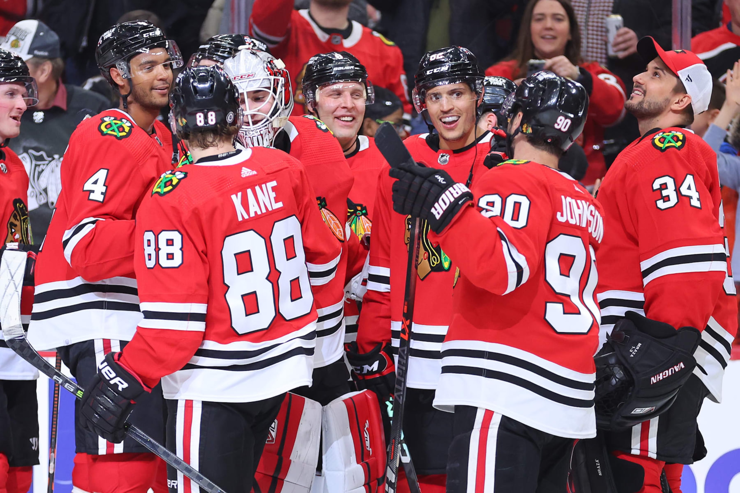 CHICAGO, ILLINOIS - FEBRUARY 10: Caleb Jones #82 of the Chicago Blackhawks celebrates teammates after scoring a game-winning goal in overtime against the Arizona Coyotes at United Center on February 10, 2023 in Chicago, Illinois. (Photo by Michael Reaves/Getty Images)