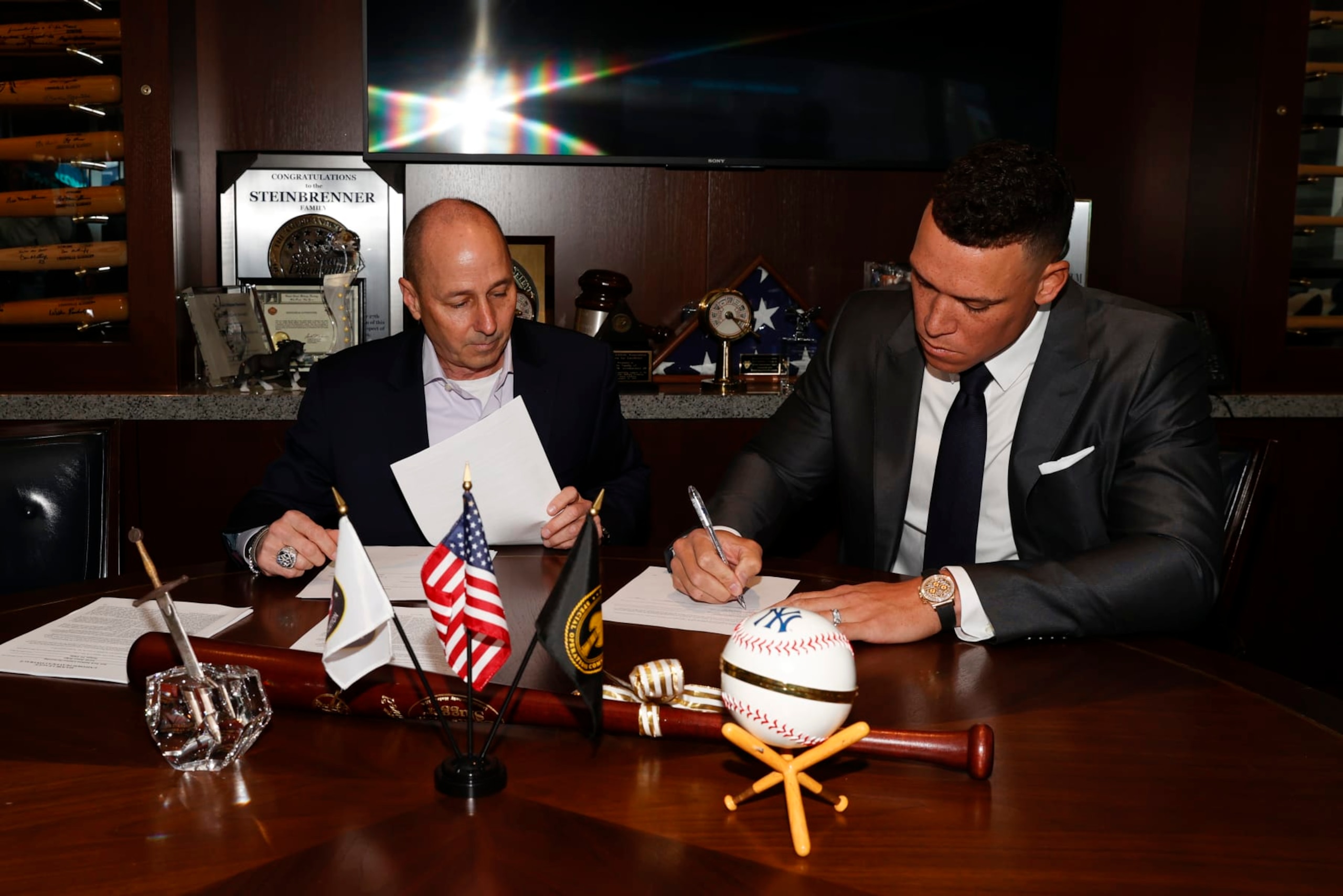 NEW YORK, NY - DECEMBER 21: General manager Brian Cashman of the New York Yankees and Aaron Judge #99 finalize Judges nine-year contract before a press conference at Yankee Stadium on December 21, 2022 in the Bronx, New York. (Photo by New York Yankees/Getty Images)