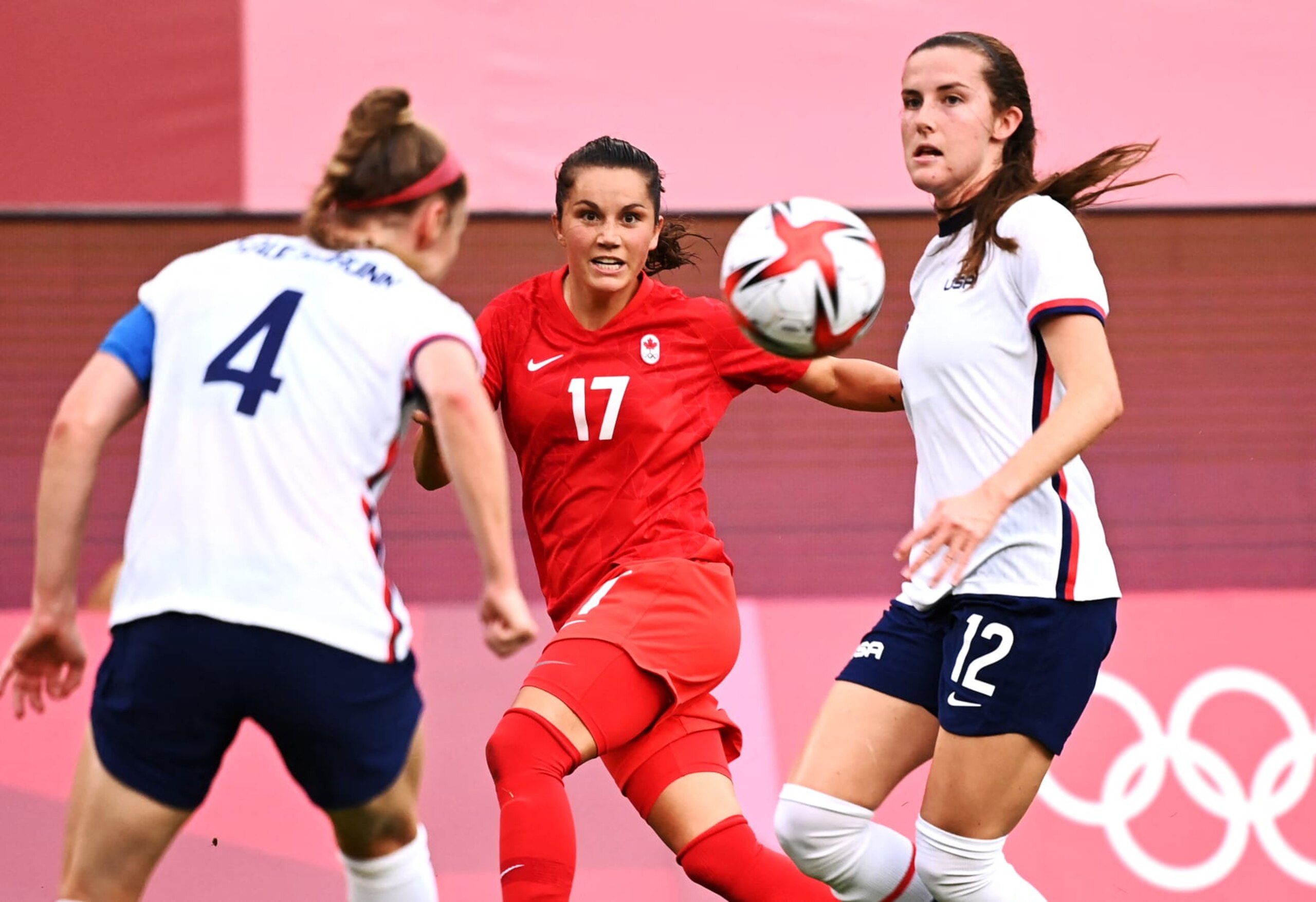Canada's midfielder Jessie Fleming (C) crosses the ball as she is closed down by USA's defender Tierna Davidson (R) and USA's defender Becky Sauerbrunn during the Tokyo 2020 Olympic Games women's semi-final football match between the United States and Canada at Ibaraki Kashima Stadium in Kashima on August 2, 2021. (Photo by Kazuhiro NOGI / AFP) (Photo by KAZUHIRO NOGI/AFP via Getty Images)