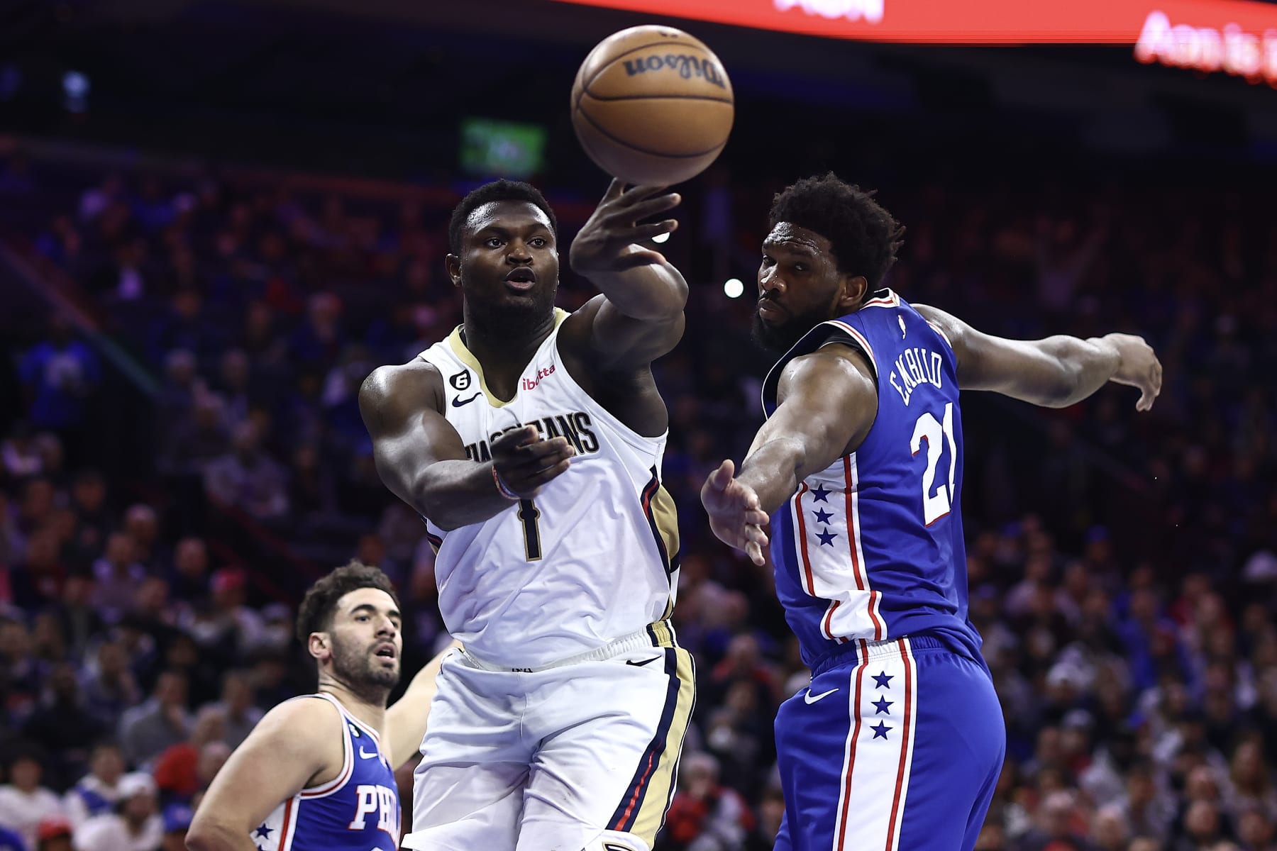 PHILADELPHIA, PENNSYLVANIA - JANUARY 02: Zion Williamson #1 of the New Orleans Pelicans passes past Joel Embiid #21 of the Philadelphia 76ers during the first quarter at Wells Fargo Center on January 02, 2023 in Philadelphia, Pennsylvania. NOTE TO USER: User expressly acknowledges and agrees that, by downloading and or using this photograph, User is consenting to the terms and conditions of the Getty Images License Agreement. (Photo by Tim Nwachukwu/Getty Images)
