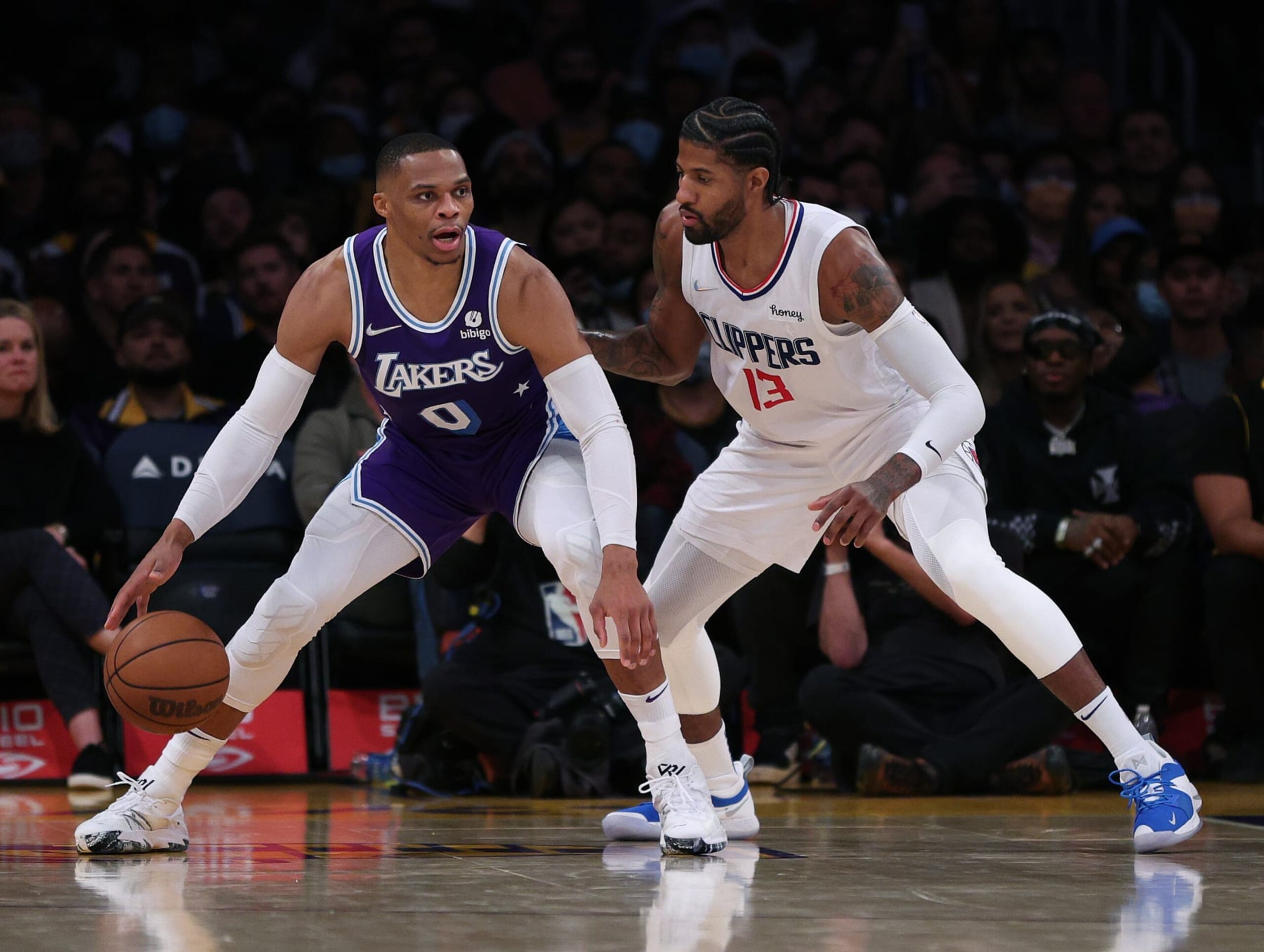 LOS ANGELES, CALIFORNIA - DECEMBER 03: Russell Westbrook #0 of the Los Angeles Lakers is defended by Paul George #13 of the LA Clippers during a 119-115 Clippers win at Staples Center on December 03, 2021 in Los Angeles, California.  NOTE TO USER: User expressly acknowledges and agrees that, by downloading and/or using this Photograph, user is consenting to the terms and conditions of the Getty Images License Agreement. Mandatory Copyright Notice: Copyright 2021 NBAE (Photo by Harry How/Getty Images)