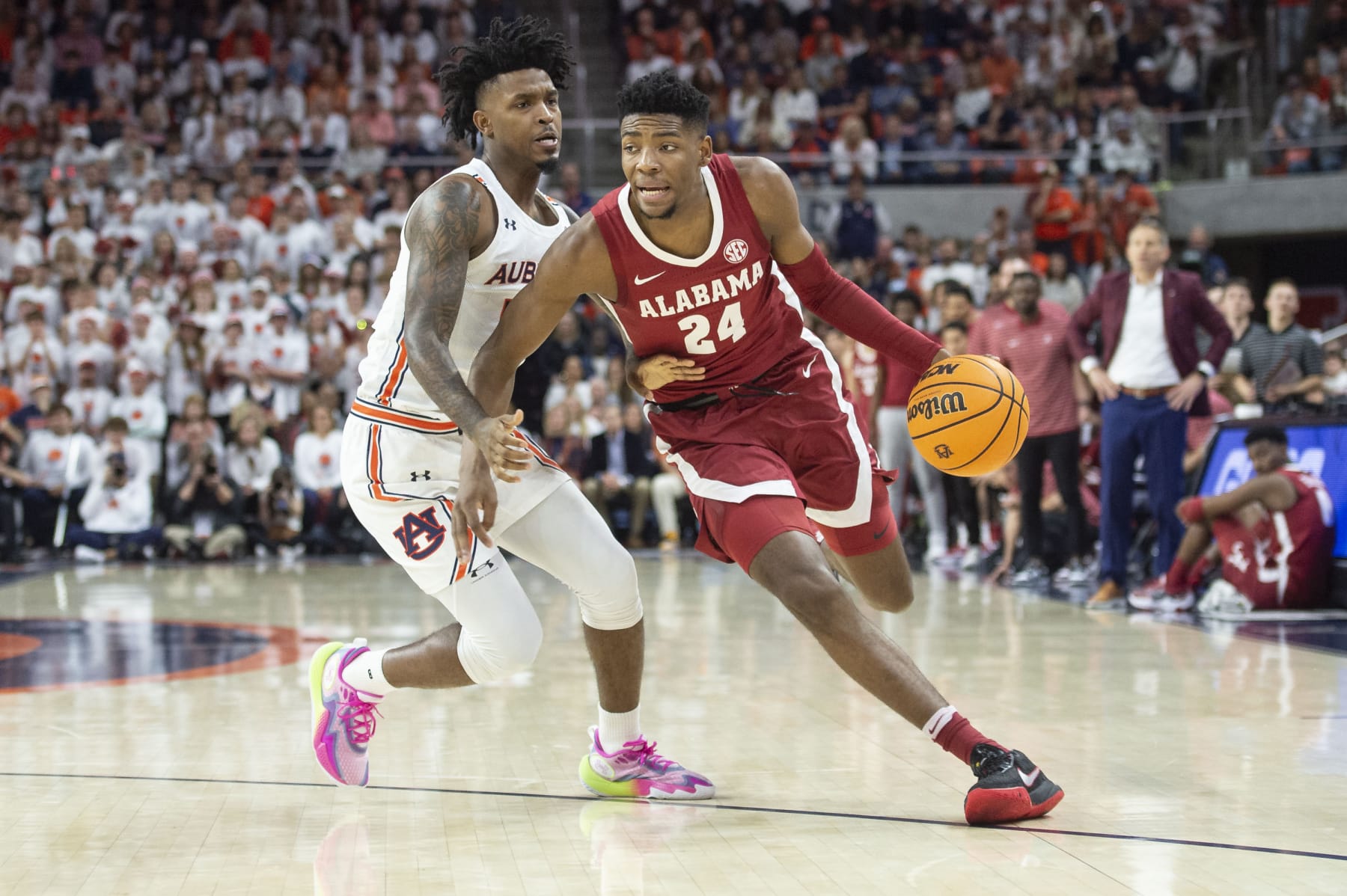 AUBURN, ALABAMA - FEBRUARY 11: Brandon Miller #24 of the Alabama Crimson Tide looks to maneuver the ball by Zep Jasper #12 of the Auburn Tigers at Neville Arena on February 11, 2023 in Auburn, Alabama. (Photo by Michael Chang/Getty Images)
