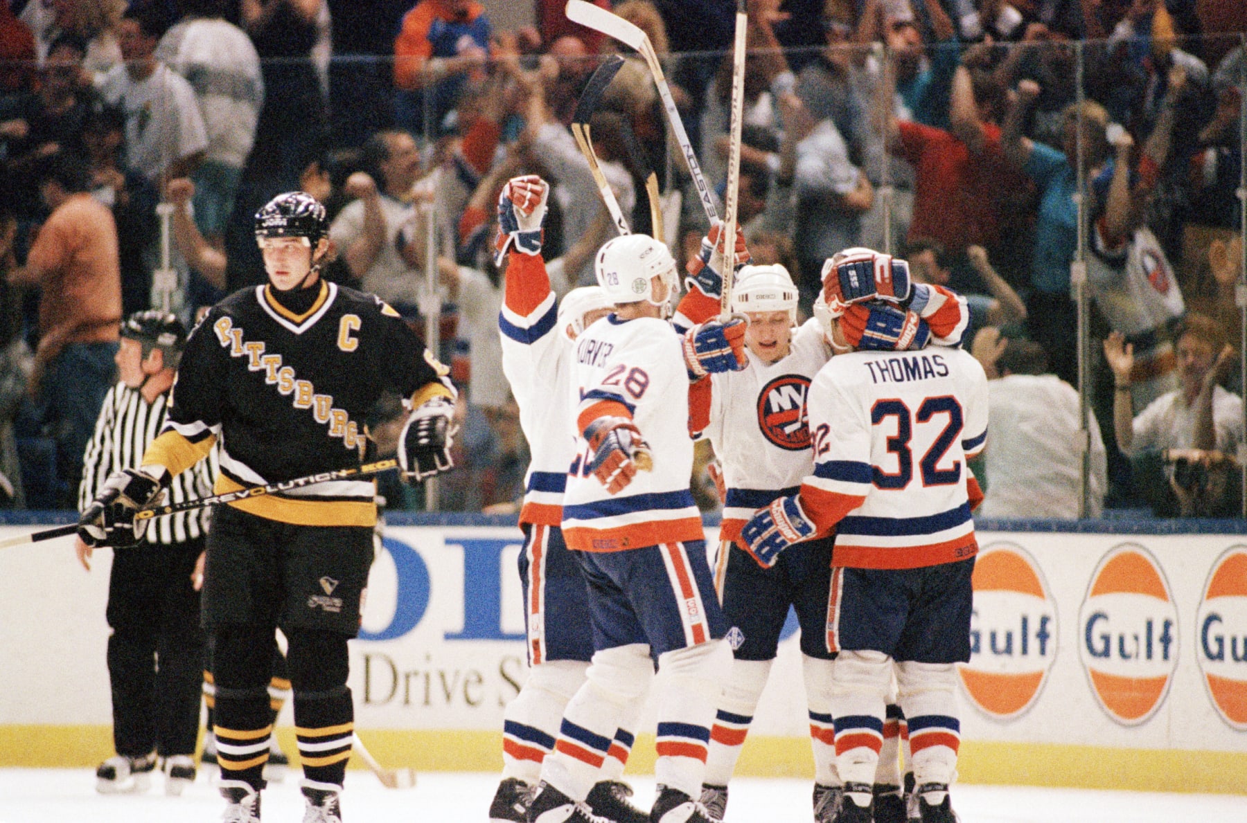 Pittsburgh Penguins captain Mario Lemieux skates away while the New York Islanders celebrate a goal during their 1993 playoff series. 
