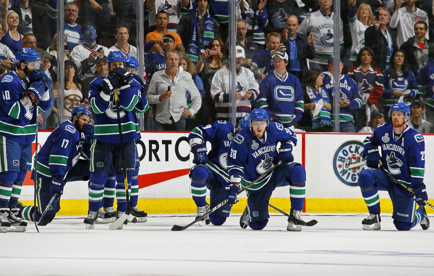 The Vancouver Canucks watch dejectedly as the Boston Bruins celebrate winning the 2011 Stanley Cup. 
