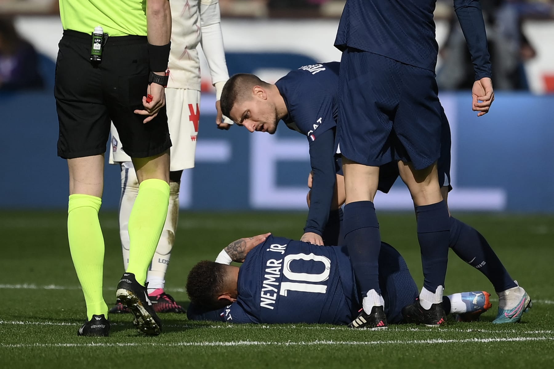 TOPSHOT - Paris Saint-Germain's Italian midfielder Marco Verratti (back) comforts Paris Saint-Germain's Brazilian forward Neymar lying on the pitch, injured following a contact with Lille's French midfielder Benjamin Andre (unseen) during the French L1 football match between Paris Saint-Germain (PSG) and Lille LOSC at The Parc des Princes Stadium in Paris on February 19, 2023. (Photo by FRANCK FIFE / AFP) (Photo by FRANCK FIFE/AFP via Getty Images)
