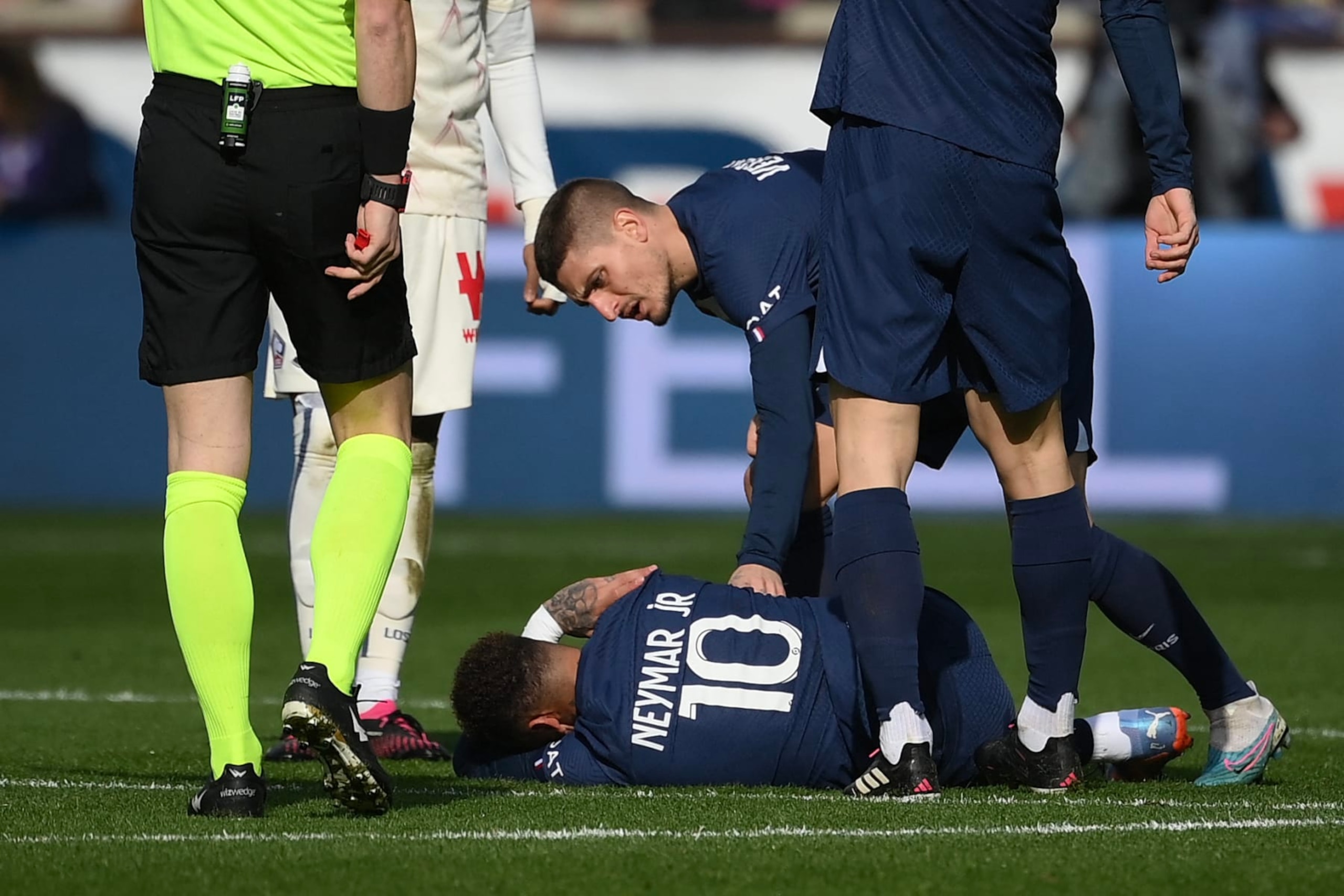 TOPSHOT - Paris Saint-Germain's Italian midfielder Marco Verratti (back) comforts Paris Saint-Germain's Brazilian forward Neymar lying on the pitch, injured following a contact with Lille's French midfielder Benjamin Andre (unseen) during the French L1 football match between Paris Saint-Germain (PSG) and Lille LOSC at The Parc des Princes Stadium in Paris on February 19, 2023. (Photo by FRANCK FIFE / AFP) (Photo by FRANCK FIFE/AFP via Getty Images)