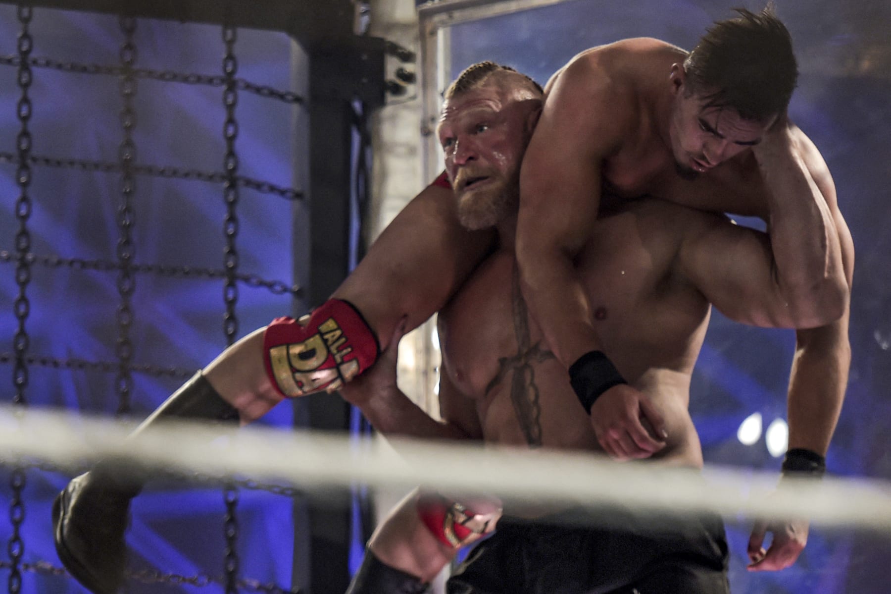Brock Lesnar carries Austin Theory as they wrestle during the 2022 WWE Elimination Chamber at the Jeddah Super Dome in Saudi Arabia's Red Sea coastal city of Jeddah on February 19, 2022. (Photo by Amer HILABI / AFP) (Photo by AMER HILABI/AFP via Getty Images)