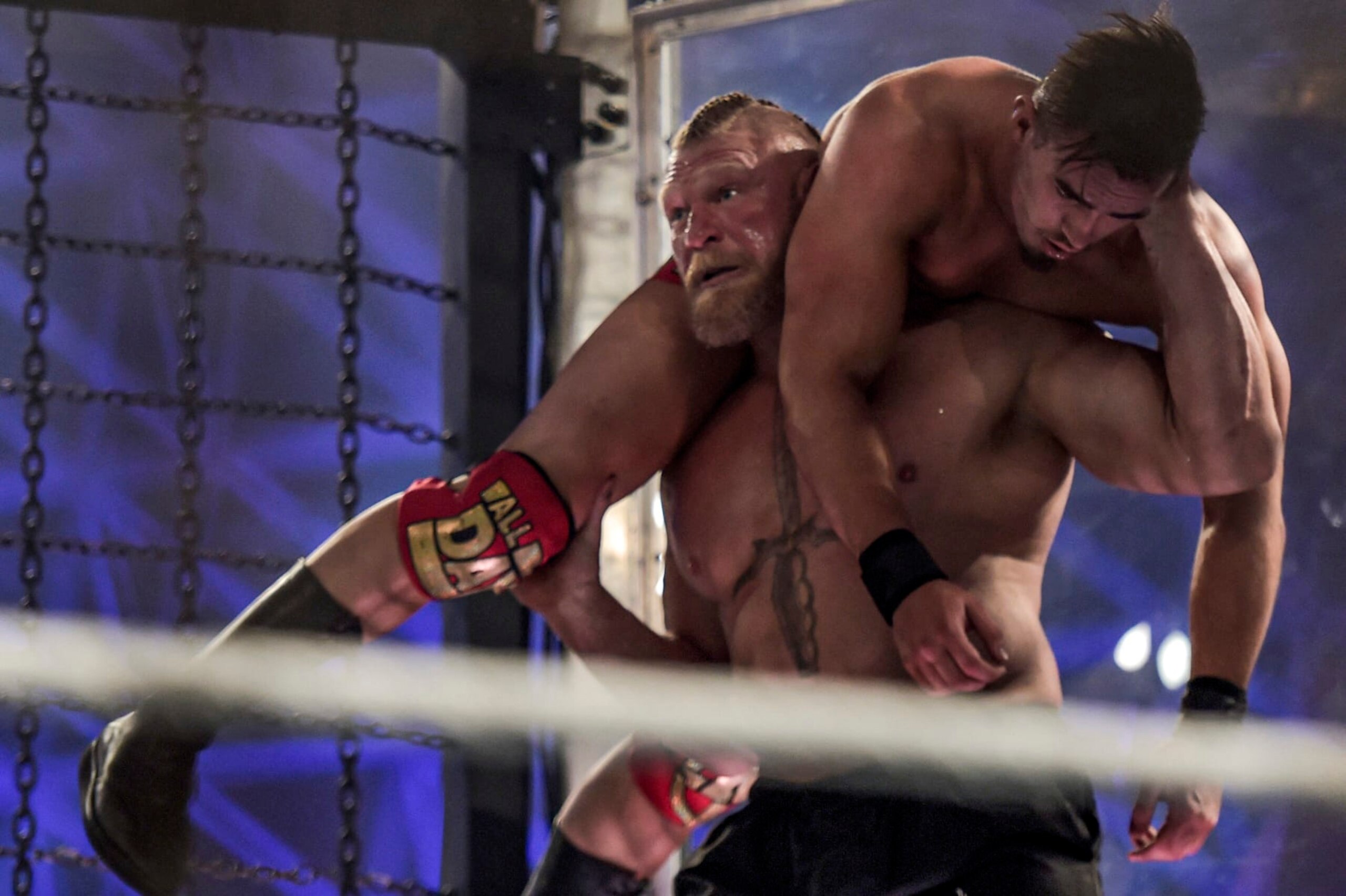 Brock Lesnar carries Austin Theory as they wrestle during the 2022 WWE Elimination Chamber at the Jeddah Super Dome in Saudi Arabia's Red Sea coastal city of Jeddah on February 19, 2022. (Photo by Amer HILABI / AFP) (Photo by AMER HILABI/AFP via Getty Images)