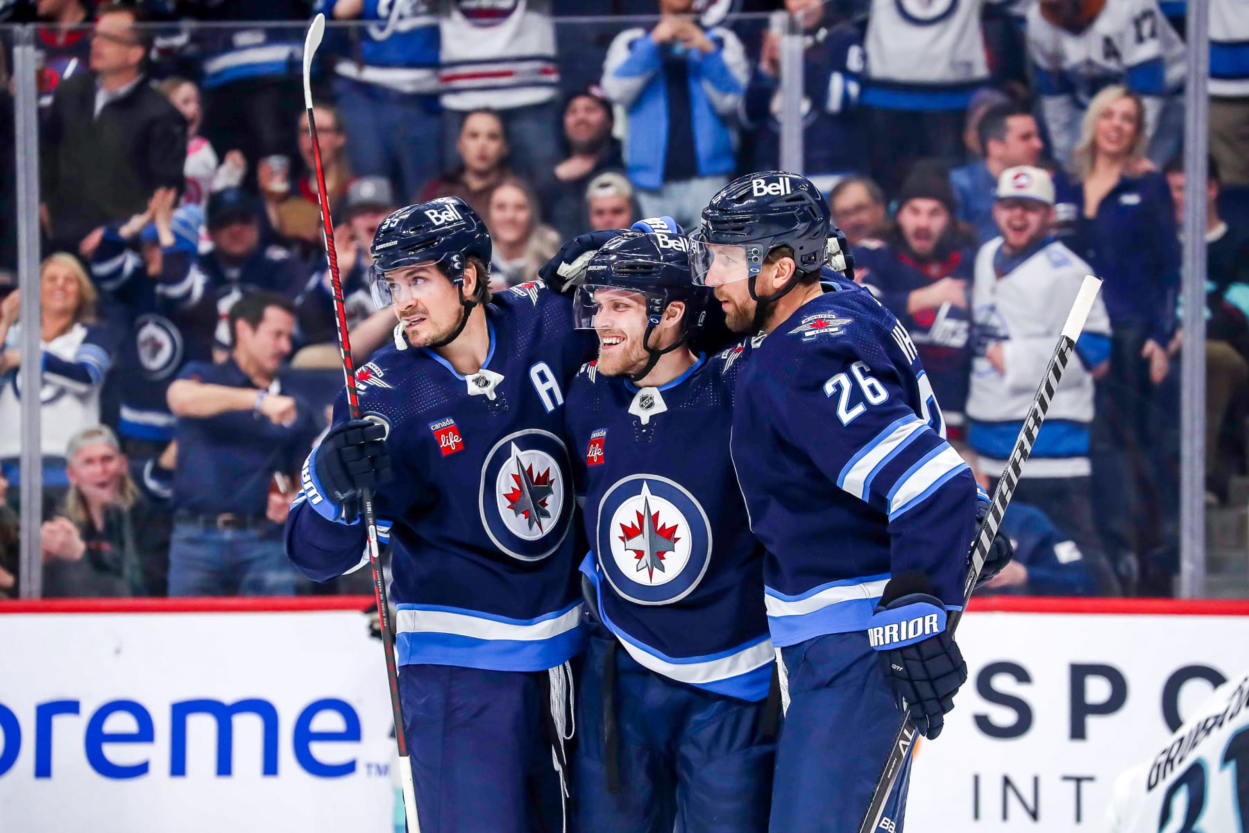 WINNIPEG, CANADA - FEBRUARY 14: Mark Scheifele #55, Nikolaj Ehlers #27 and Blake Wheeler #26 of the Winnipeg Jets celebrate a second period goal against the Seattle Kraken at the Canada Life Centre on February 14, 2023 in Winnipeg, Manitoba, Canada. (Photo by Darcy Finley/NHLI via Getty Images)