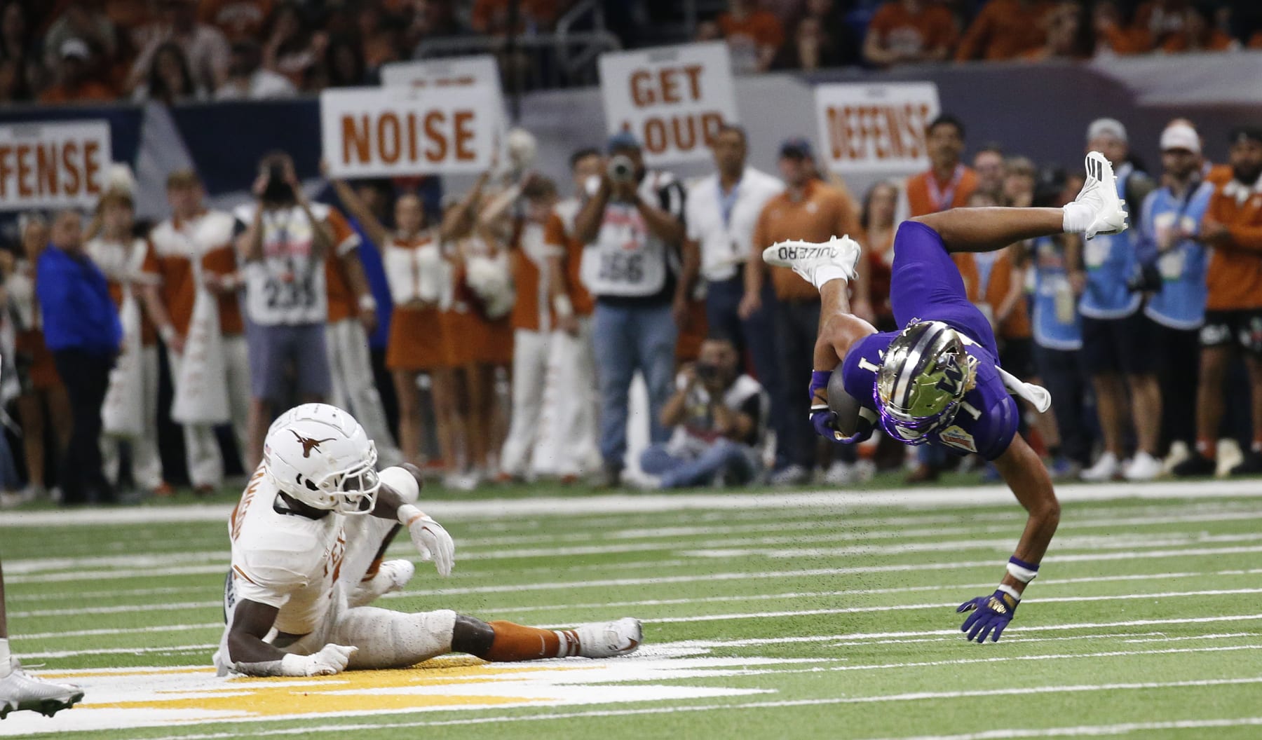 SAN ANTONIO, TX - DECEMBER 29: Rome Odunze #1 of the Washington Huskies is upended by DShawn Jamison #5 of the Texas Longhorns  in the  second half in the Valero Alamo Bowl at the Alamodome on December 29, 2022 in San Antonio, Texas.  (Photo by Ronald Cortes/Getty Images)