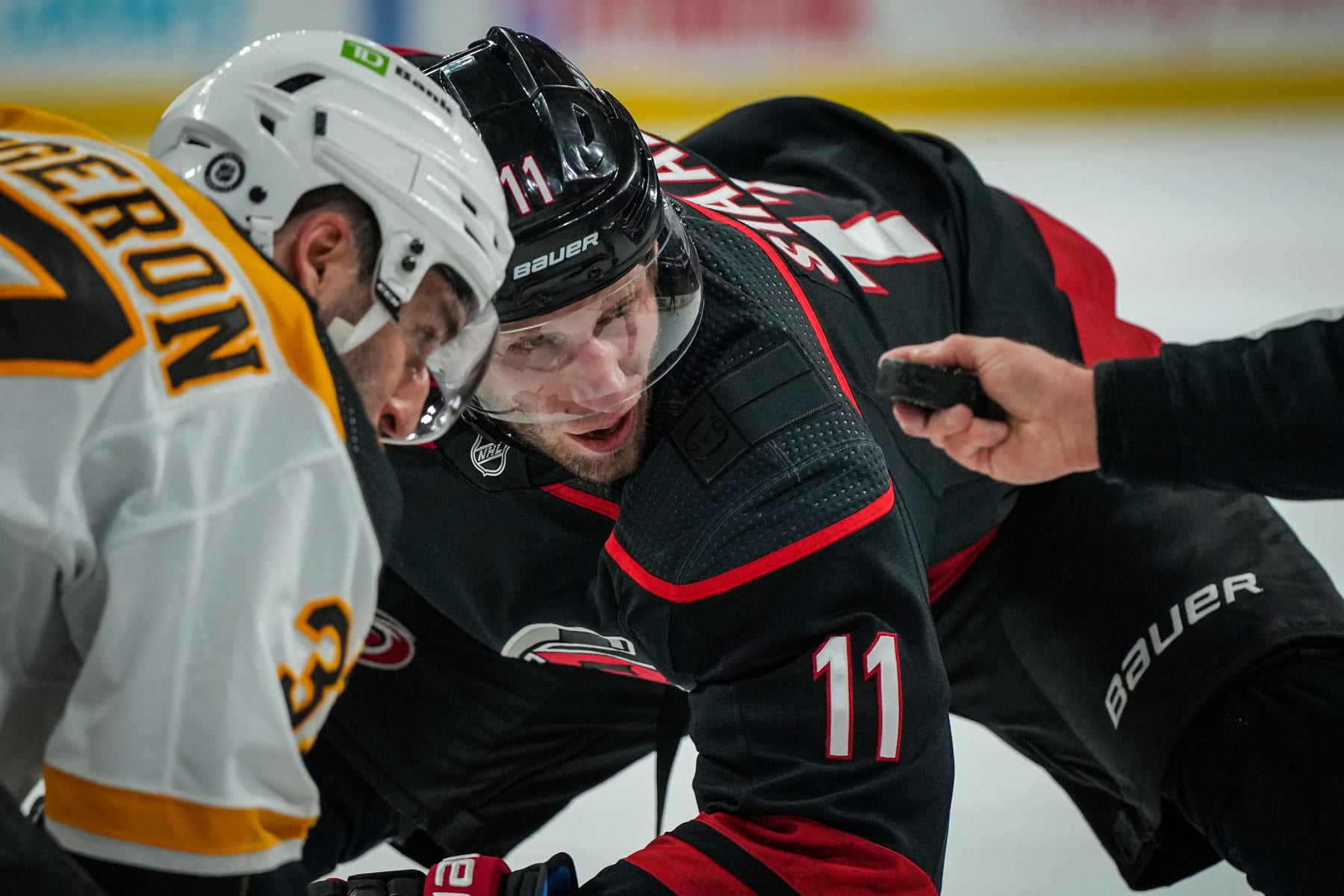 RALEIGH, NORTH CAROLINA - JANUARY 29: Jordan Staal #11 of the Carolina Hurricanes faces off with Patrice Bergeron #37 of the Boston Bruins during the first period at PNC Arena on January 29, 2023 in Raleigh, North Carolina. (Photo by Josh Lavallee/NHLI via Getty Images)