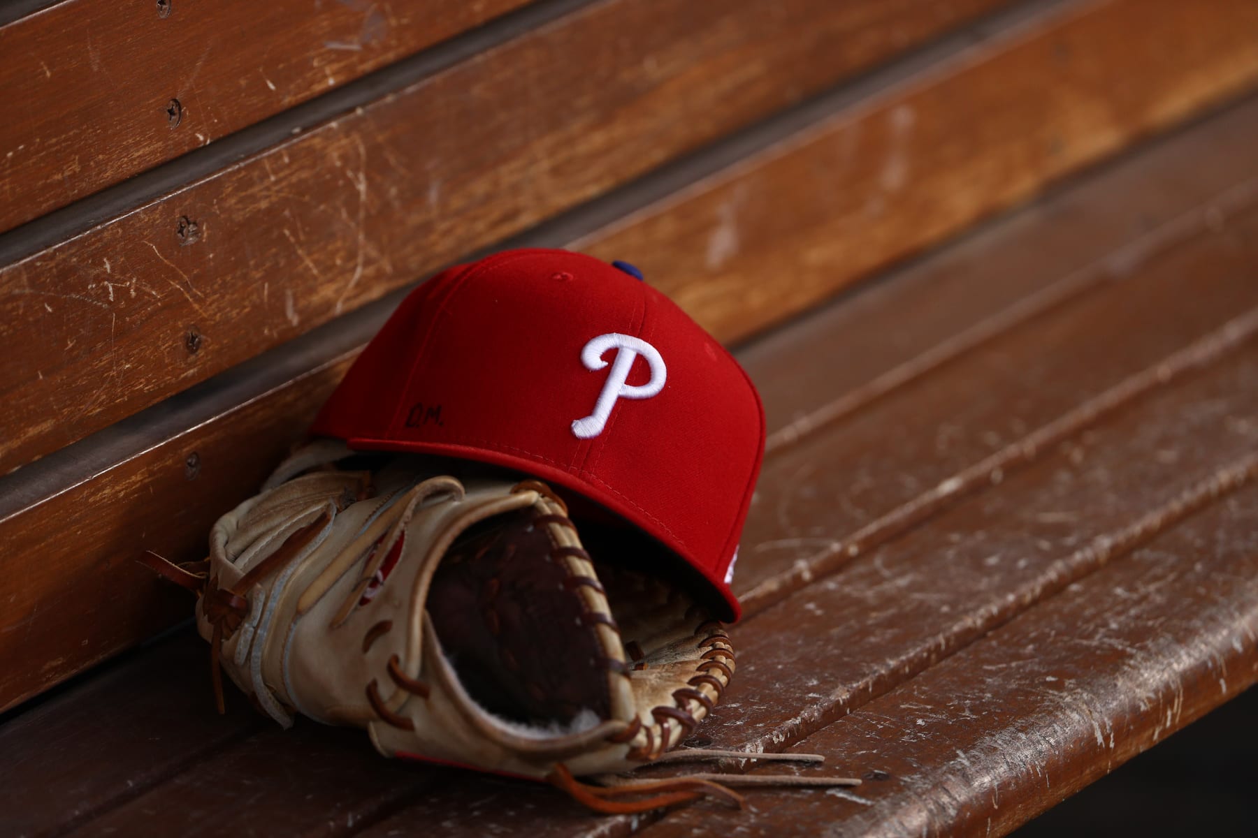 LOS ANGELES, CALIFORNIA - JUNE 01: A detailed view of a glove and Philadelphia Phillies hat is seen in the dugout prior to the MLB game between the Philadelphia Phillies and the Los Angeles Dodgers at Dodger Stadium on June 01, 2019 in Los Angeles, California. The Dodgers defeated the Phillies 4-3. (Photo by Victor Decolongon/Getty Images)